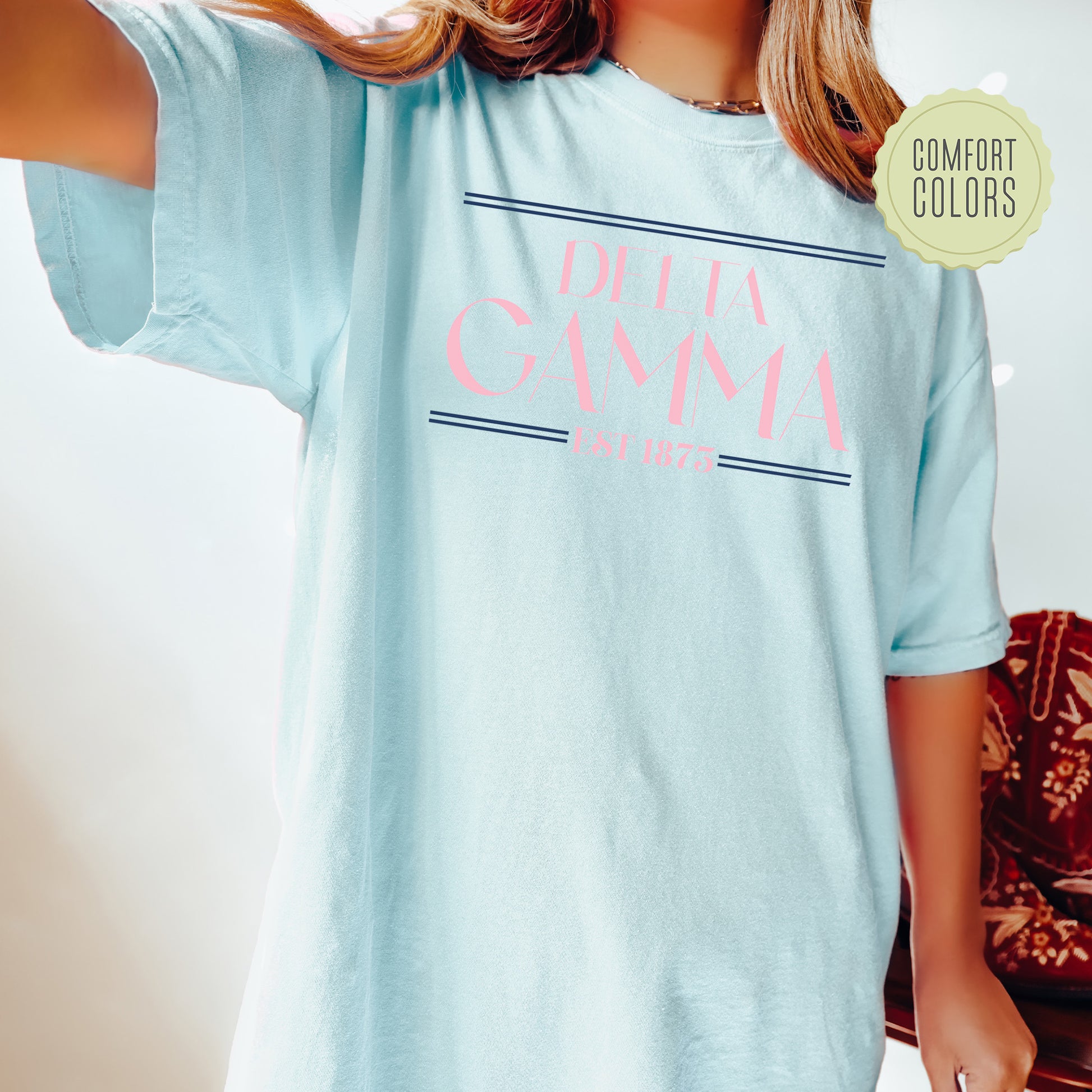 a woman wearing a light blue shirt with pink writing on it