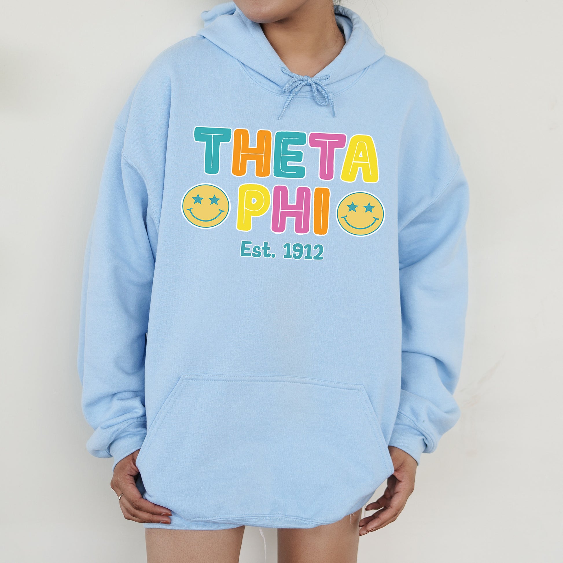 a person wearing a blue hoodie that says thea phi est 1932