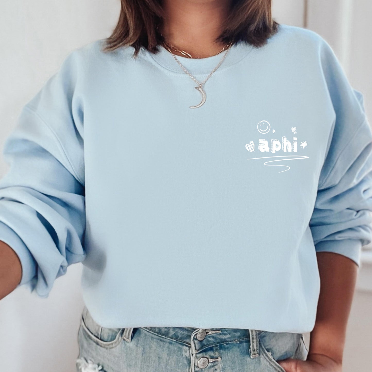 a woman wearing a light blue sweatshirt with the word asashi printed on it