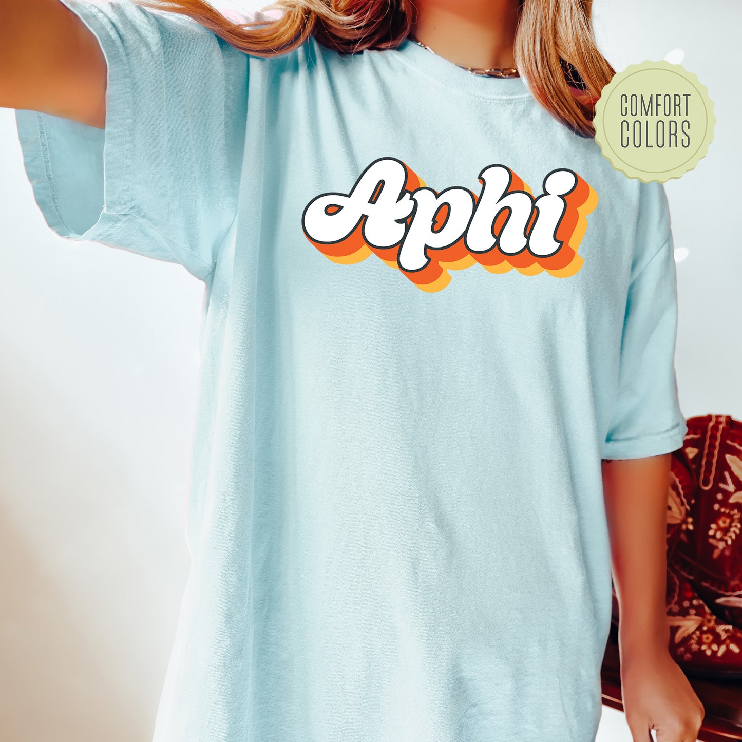 a woman wearing a blue shirt with the word aphi on it