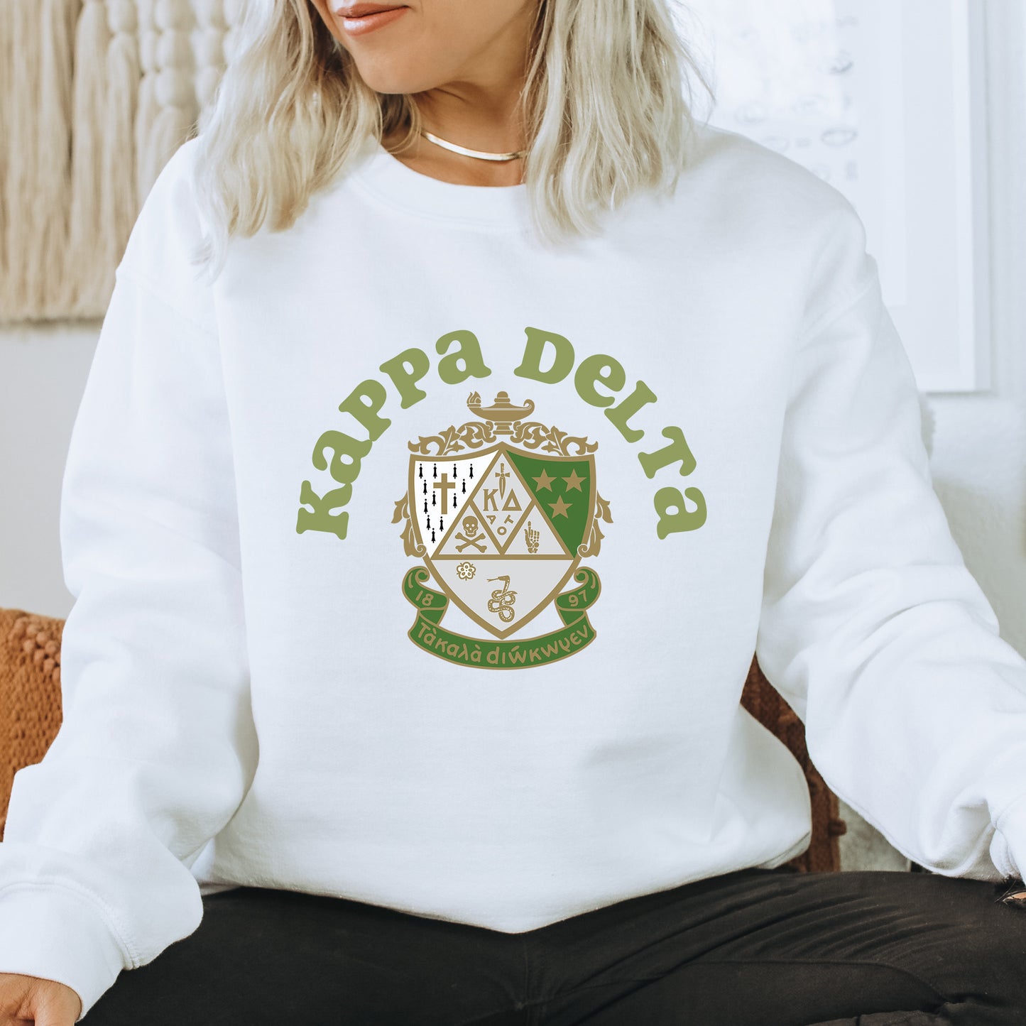a woman sitting on a chair wearing a white sweatshirt