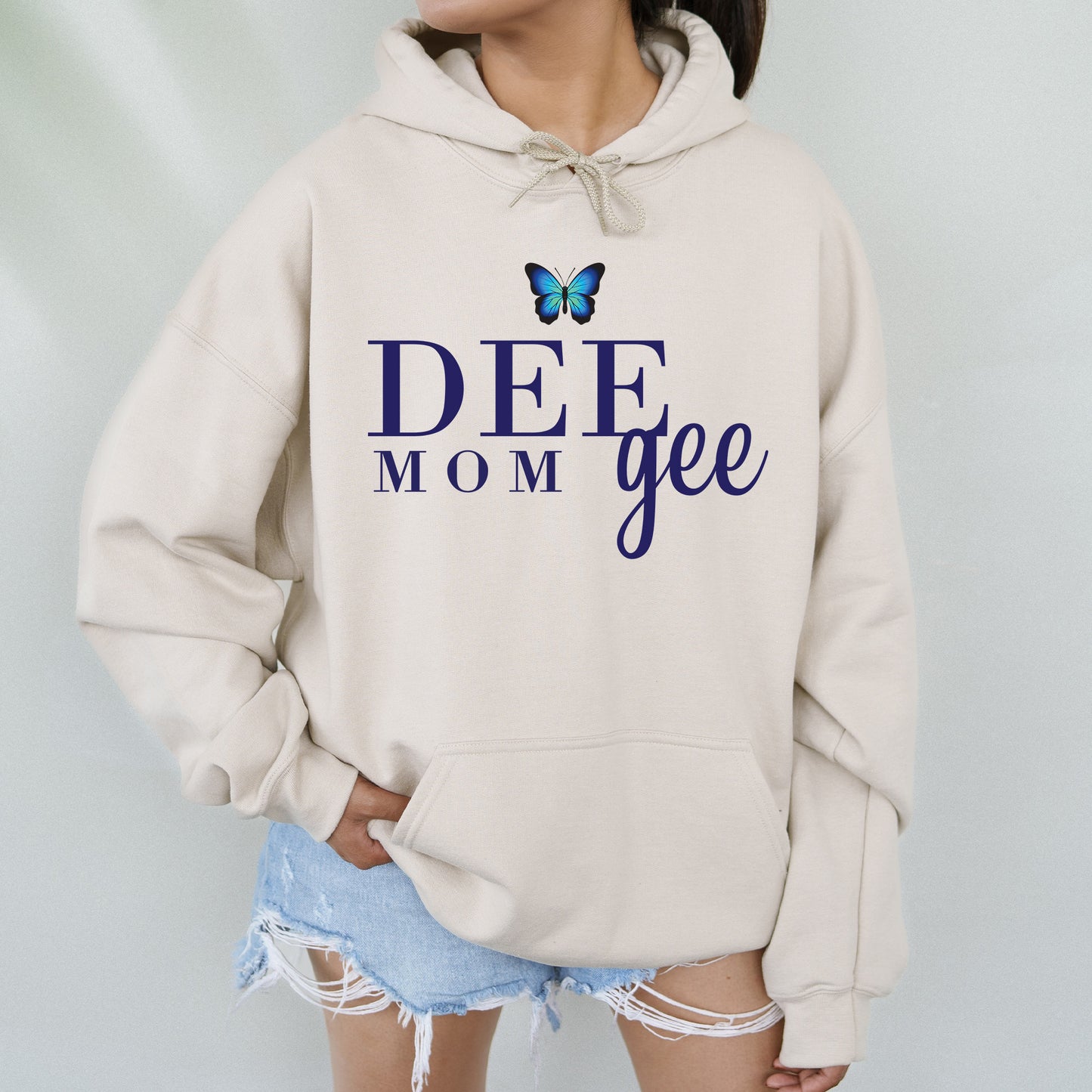 a woman wearing a sweatshirt that says deee mom gee