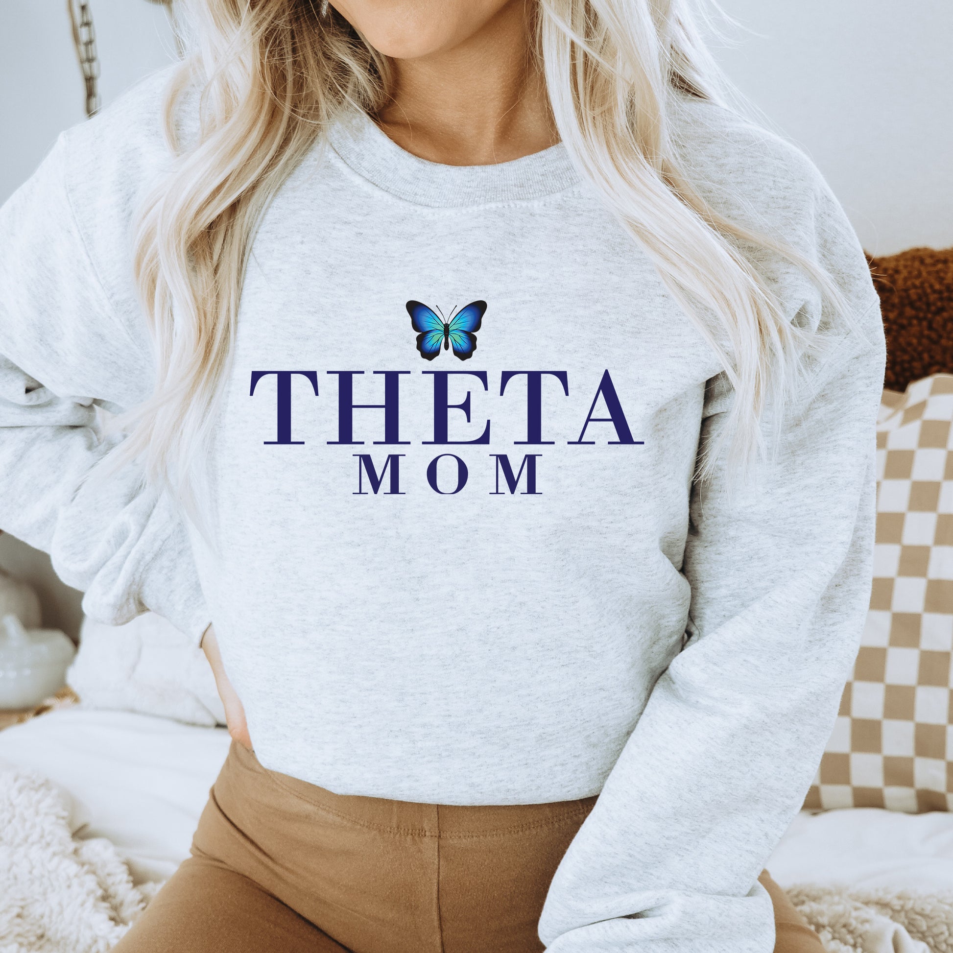a woman wearing a sweatshirt that says,'thea mom '
