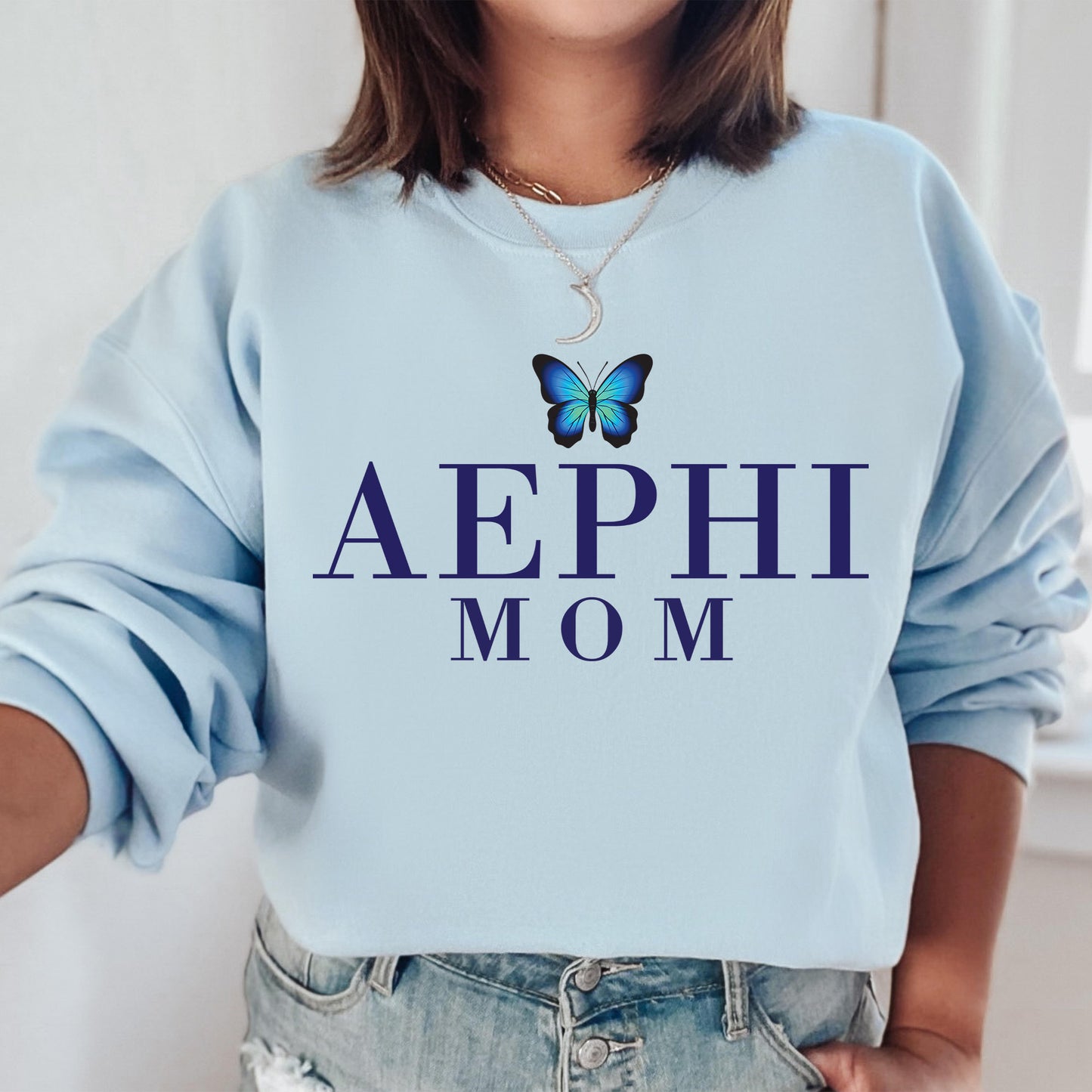a woman wearing a blue sweatshirt with a butterfly on it