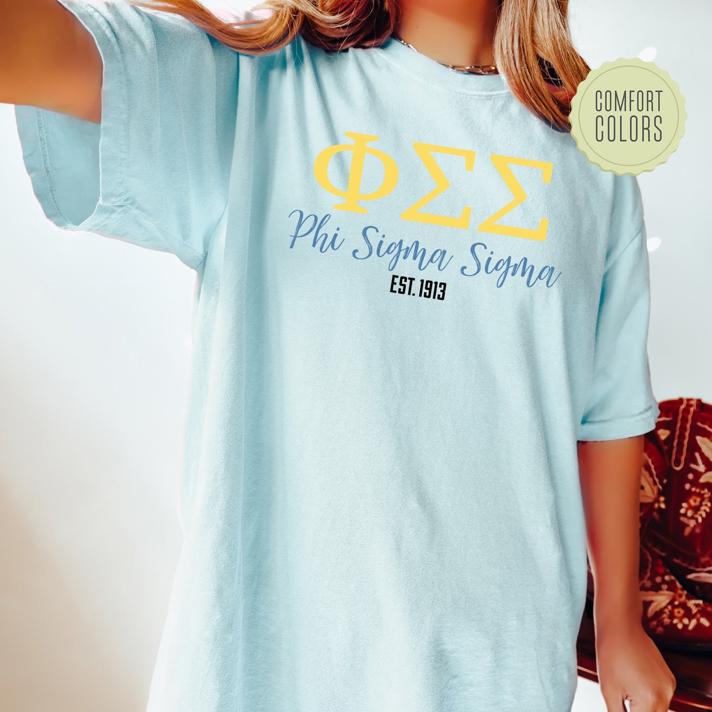 a woman wearing a light blue phi phi t - shirt
