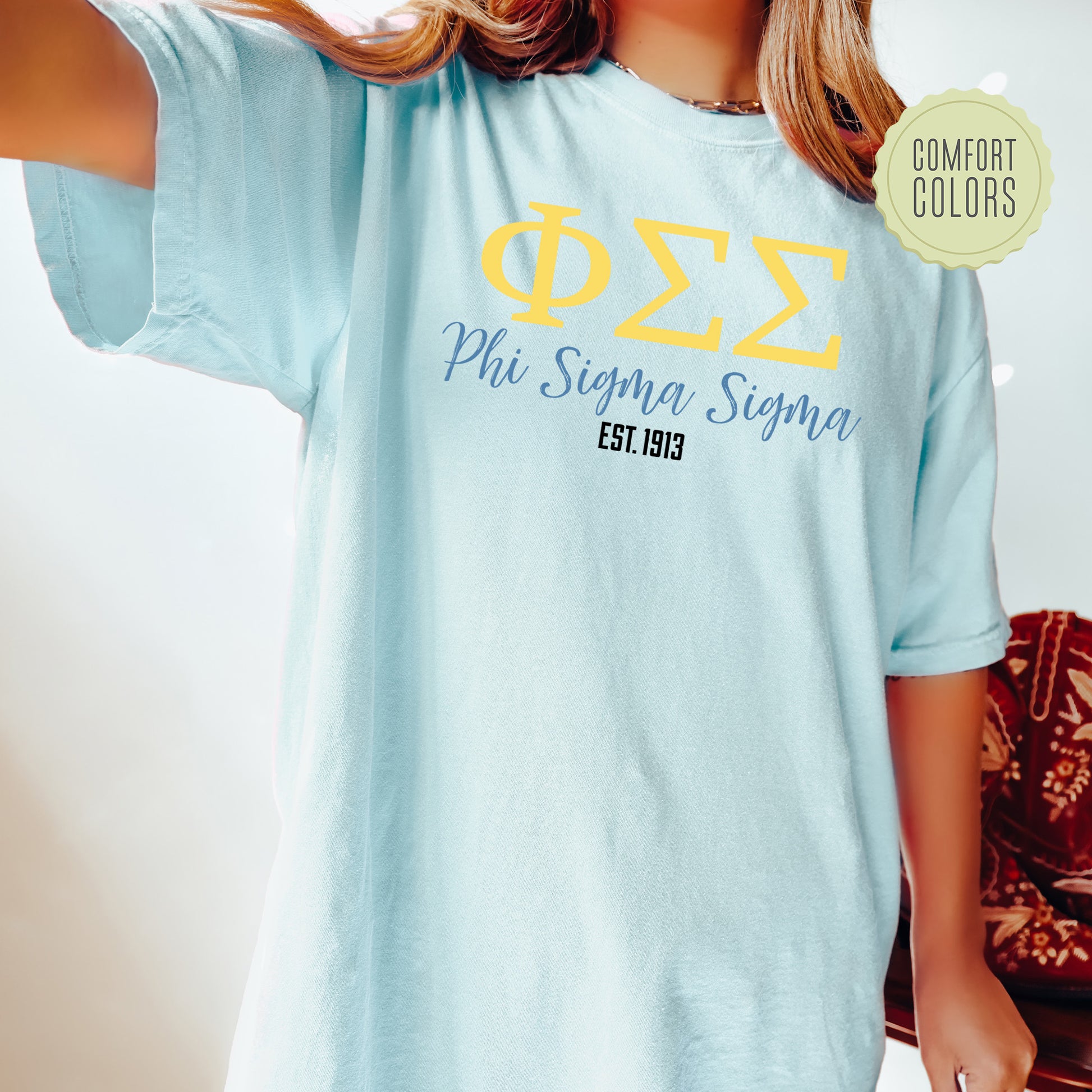 a woman wearing a light blue phi phi t - shirt