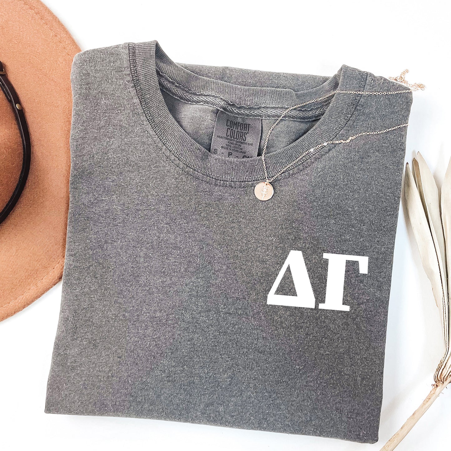 a hat, sunglasses, and a t - shirt on a white surface