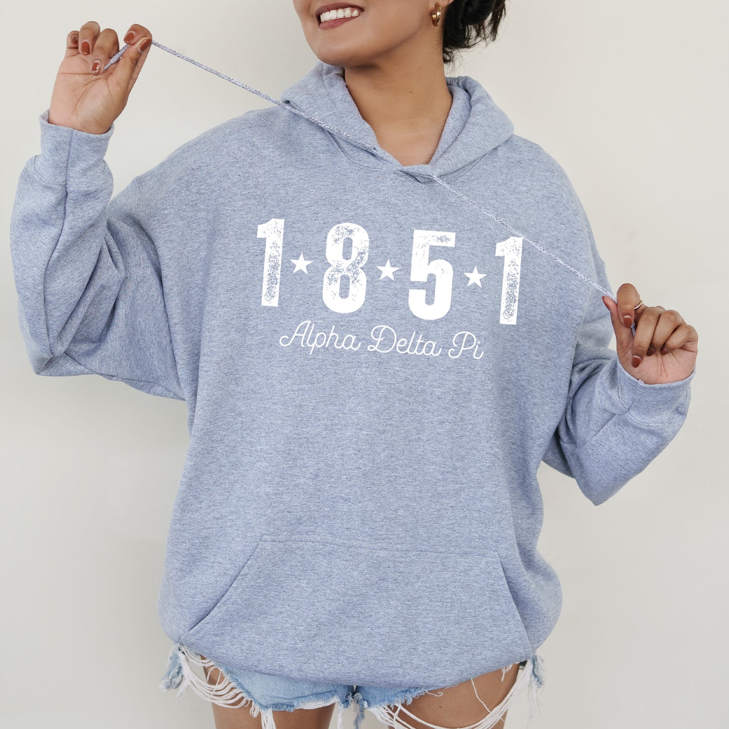 a woman in a blue sweatshirt is holding a toothbrush
