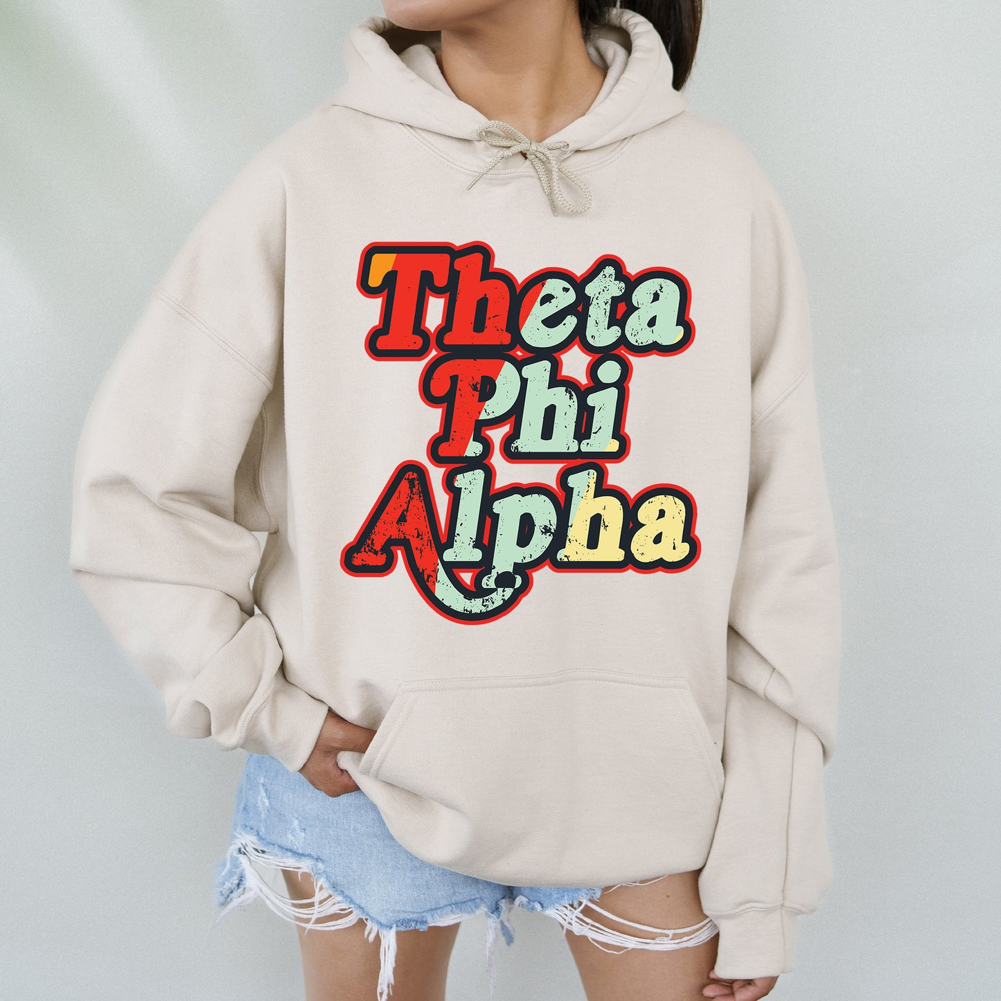 a woman wearing a white hoodie that says thea phi phi aha