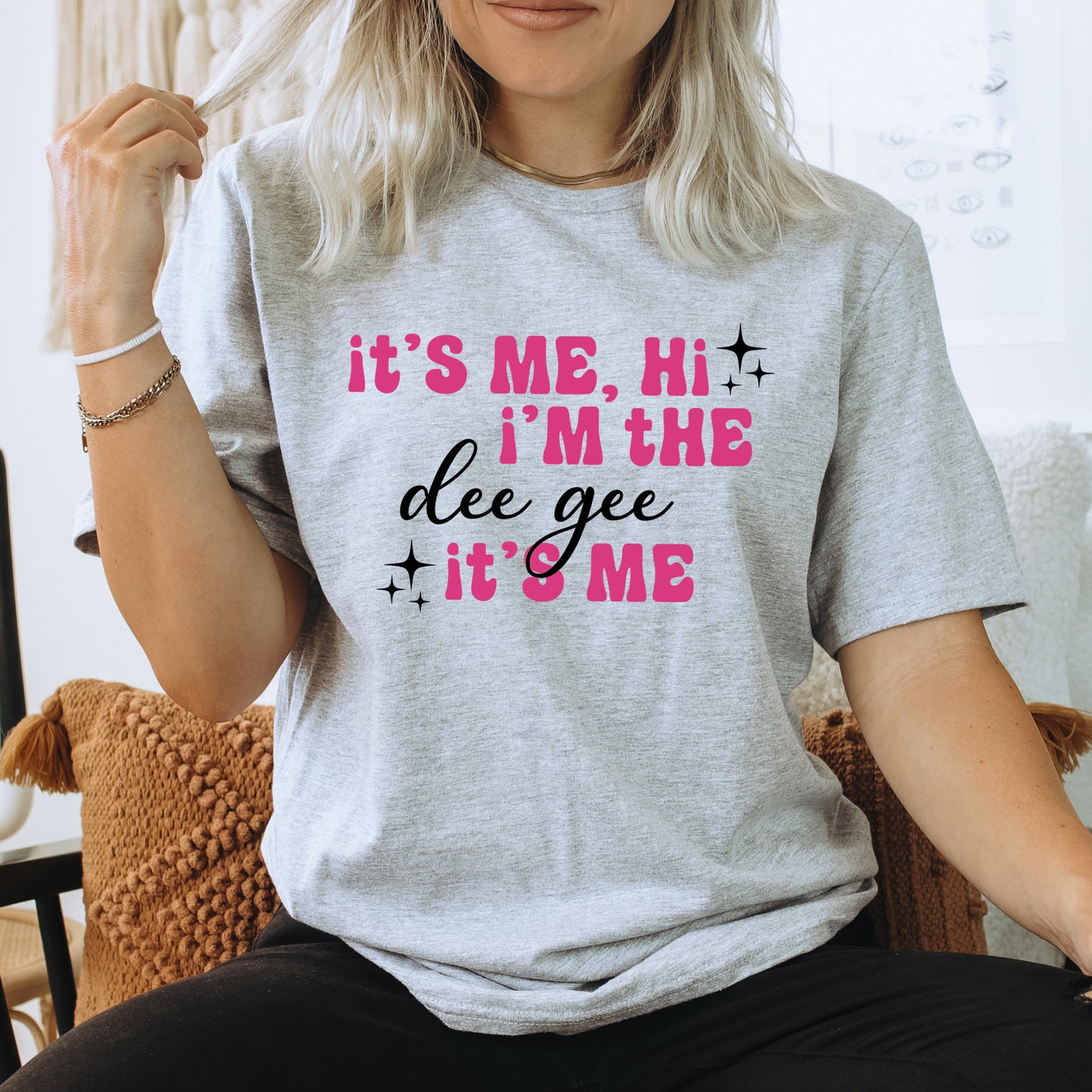 a woman sitting on a chair wearing a t - shirt that says it's
