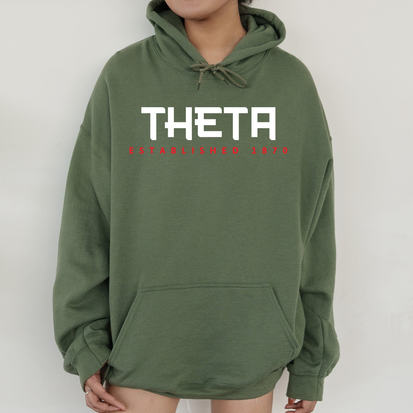 a woman wearing a green sweatshirt with the word thea printed on it
