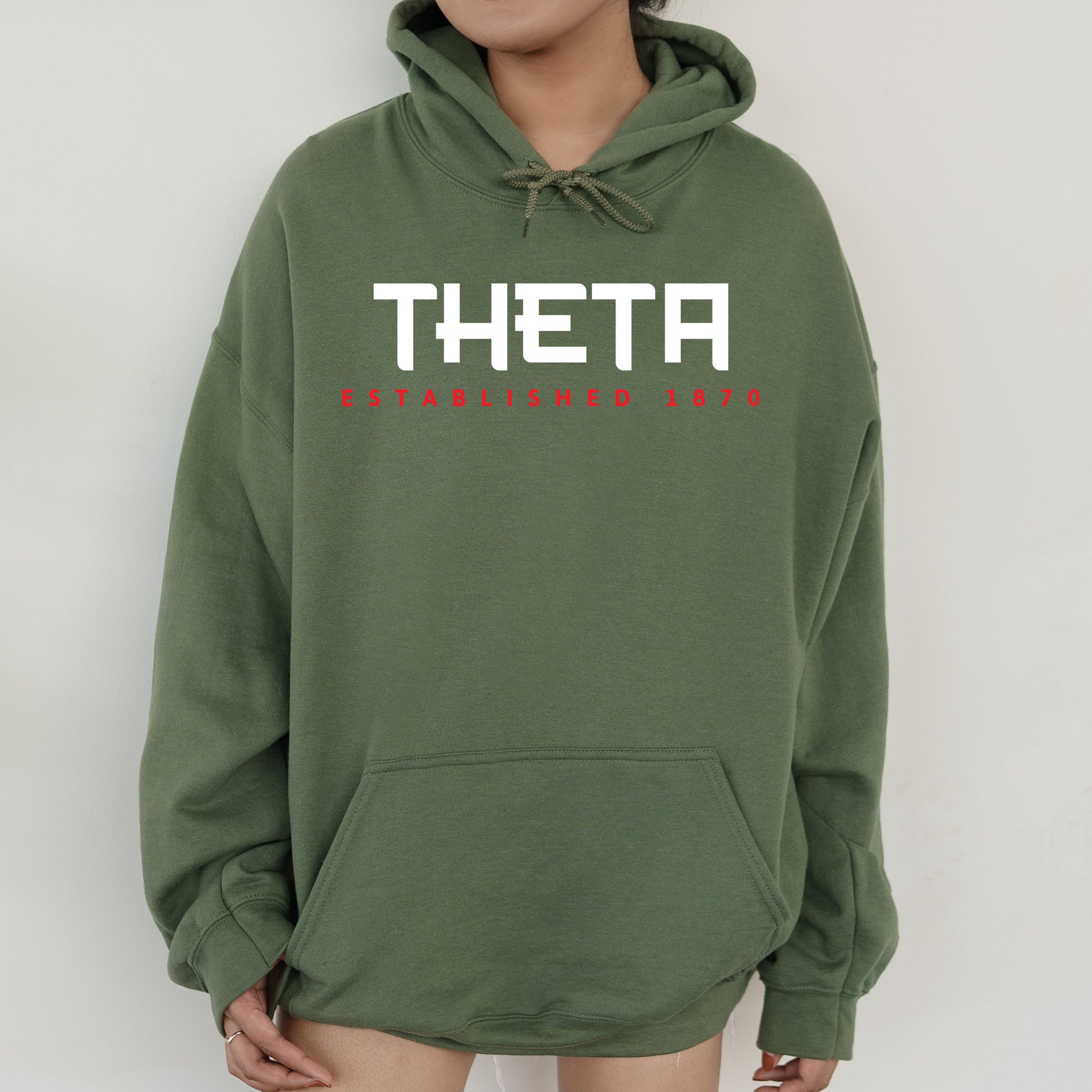 a woman wearing a green sweatshirt with the word thea printed on it