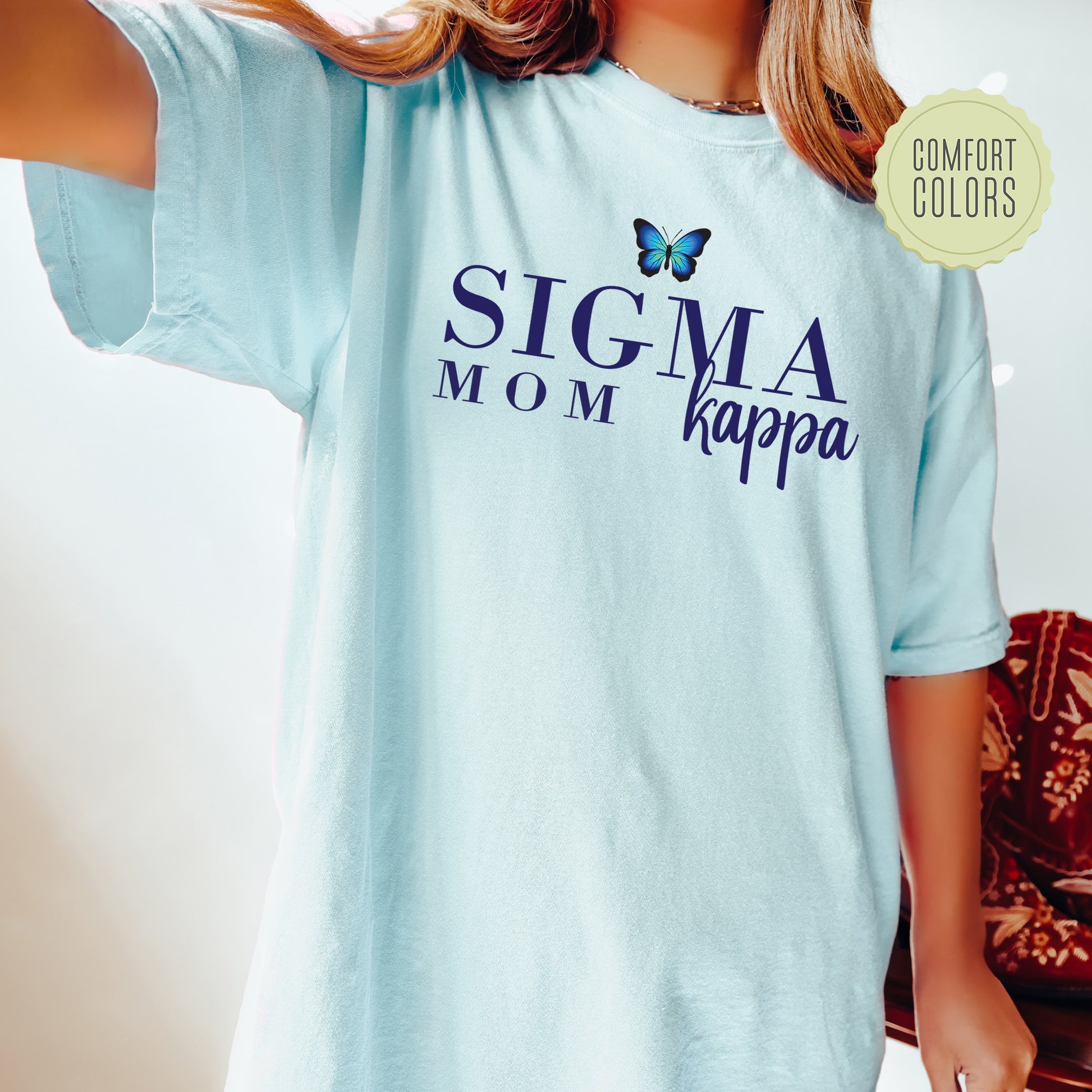 a woman wearing a t - shirt that says stigmaa mom kappa