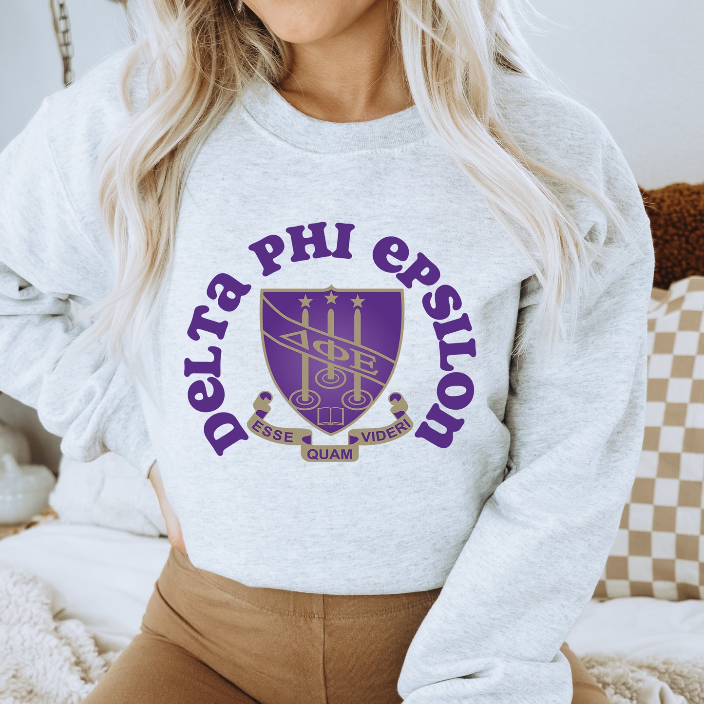 a woman wearing a sweatshirt that says delta phi epsilon
