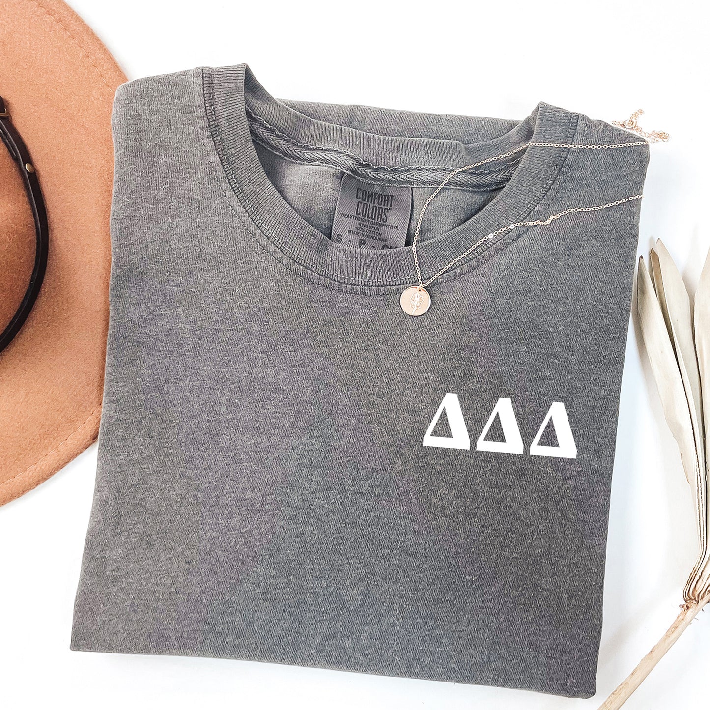 a hat, sunglasses, and a t - shirt on a white surface