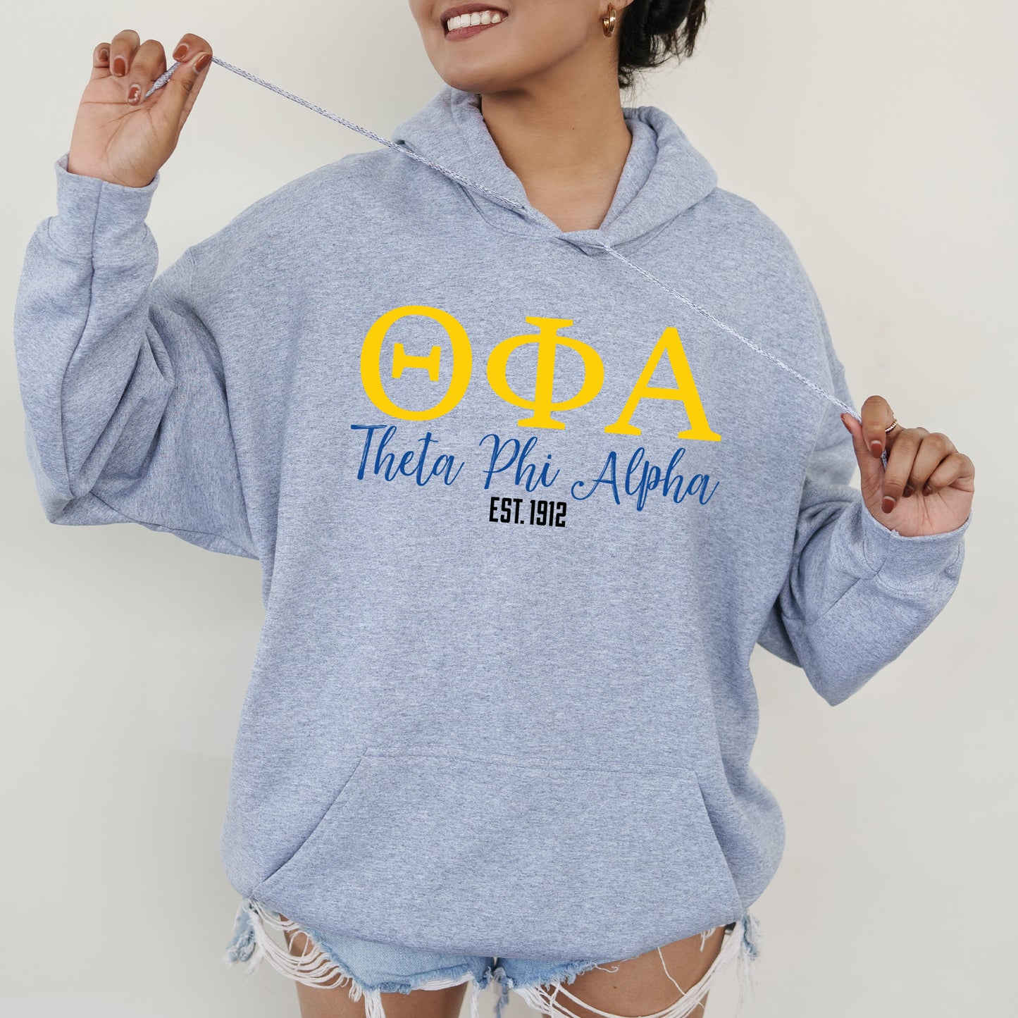 a woman in a blue hoodie is holding a toothbrush