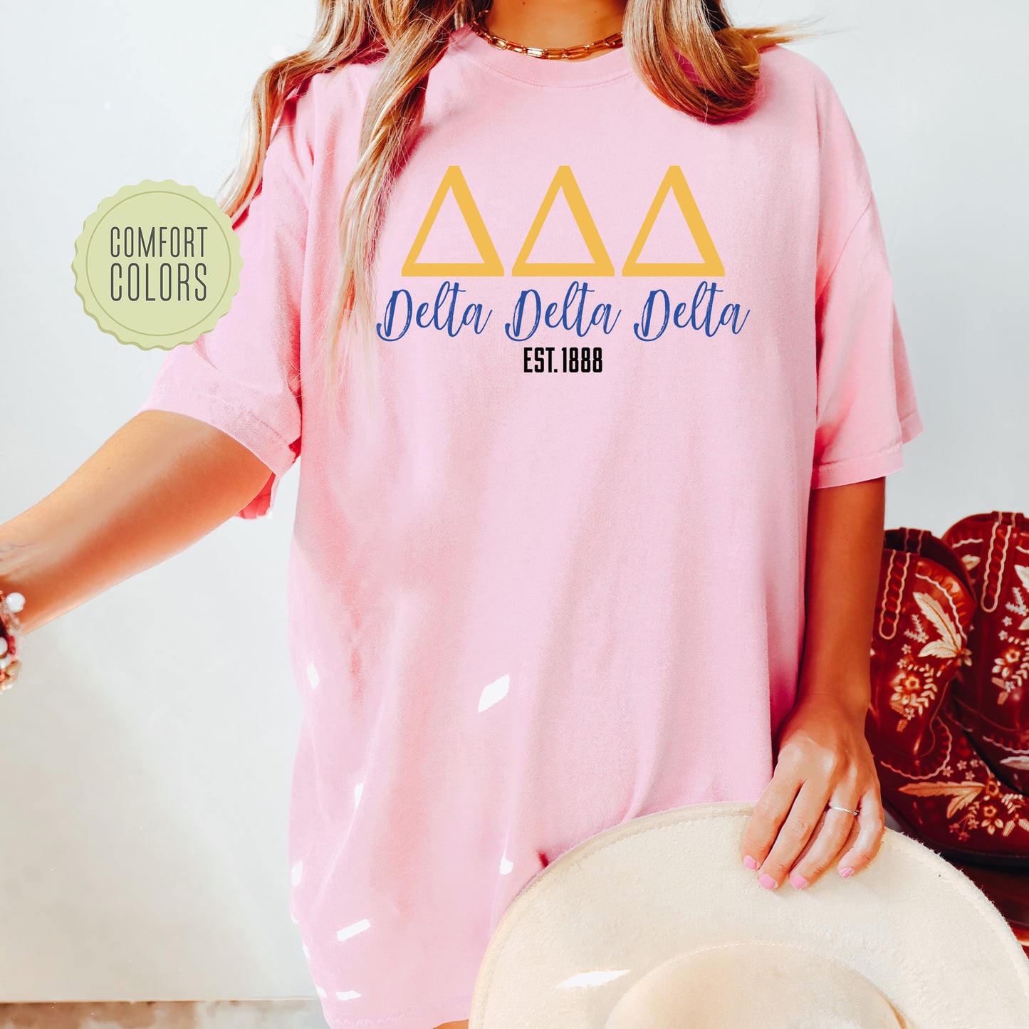 a woman wearing a pink delta delta shirt