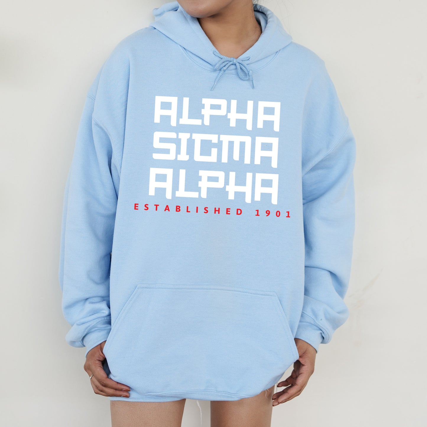 a person wearing a blue hoodie with the words alpha and alph