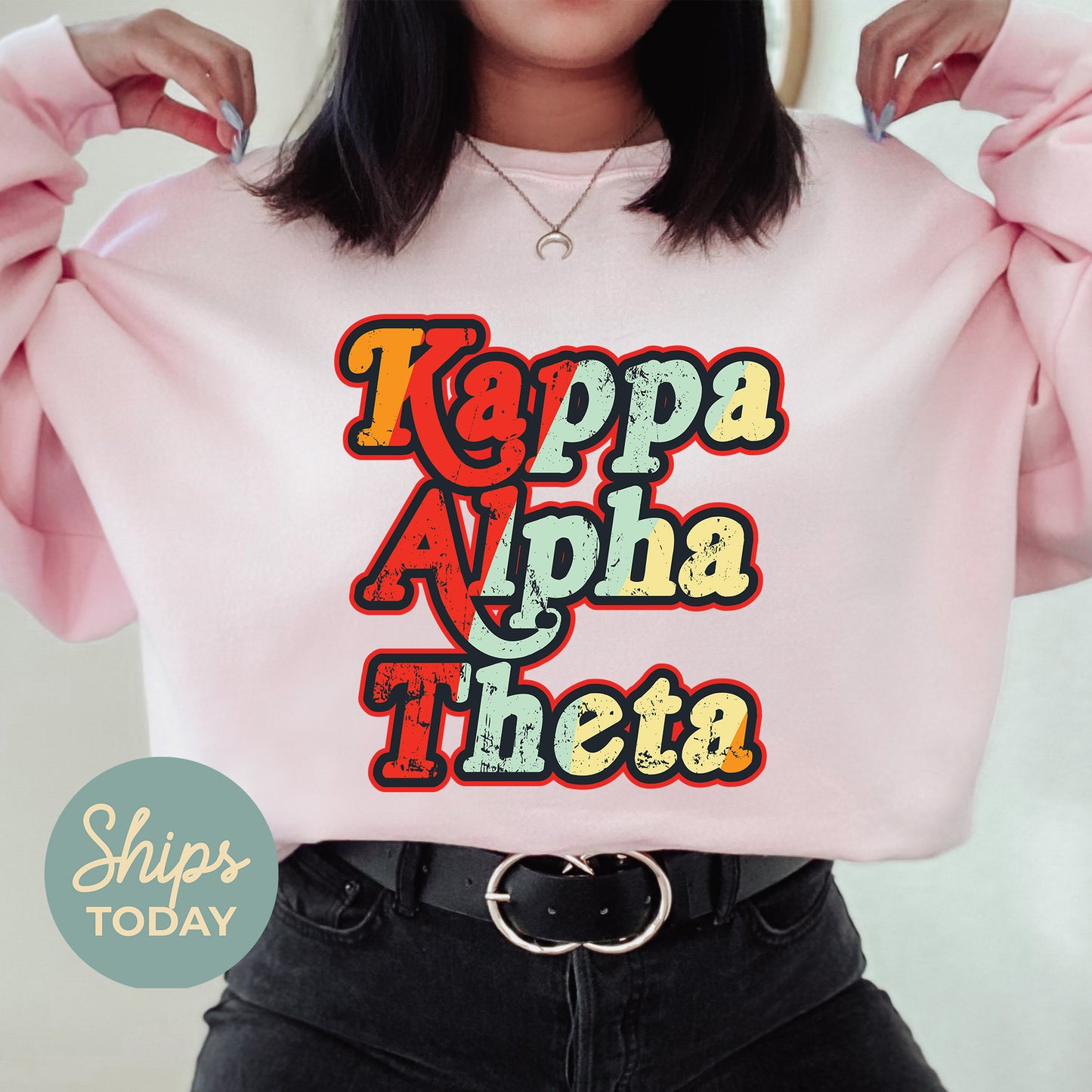 a woman wearing a pink sweatshirt with the words kappa alpha thea