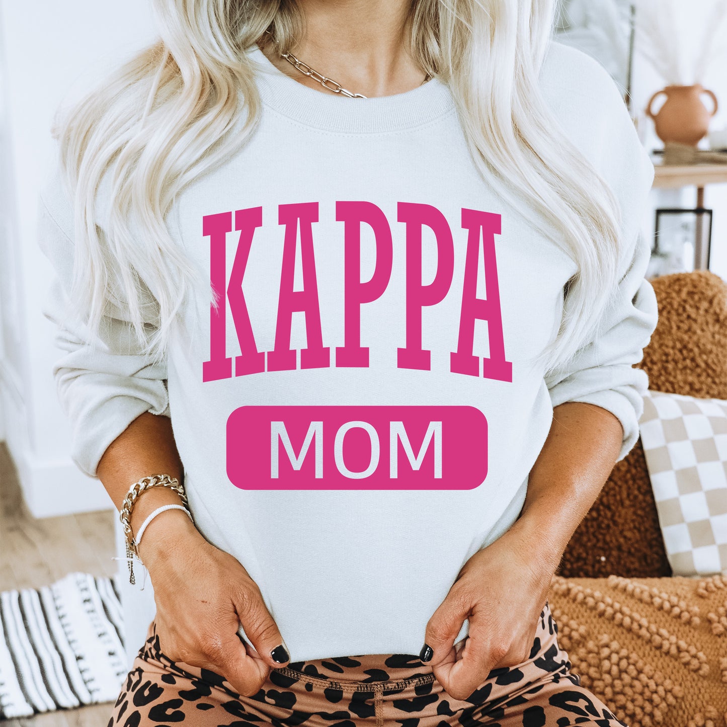 a woman wearing a sweatshirt that says kappa mom