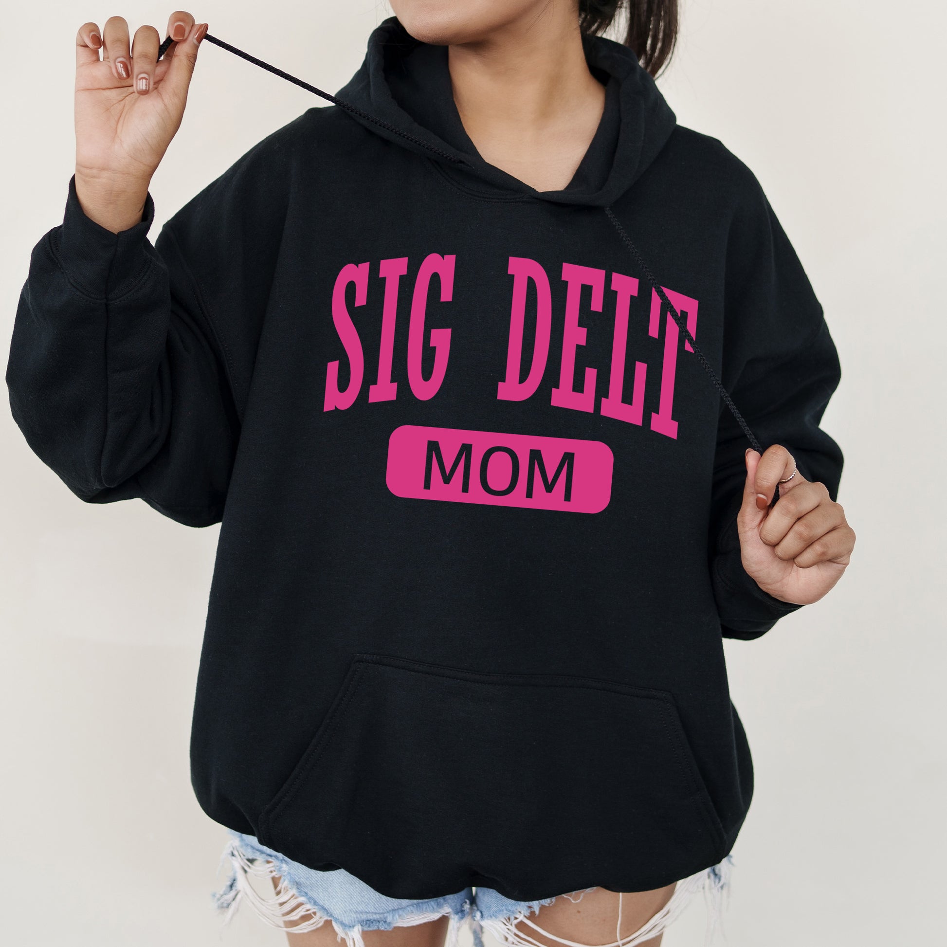 a woman wearing a black sweatshirt with a pink slogan on it