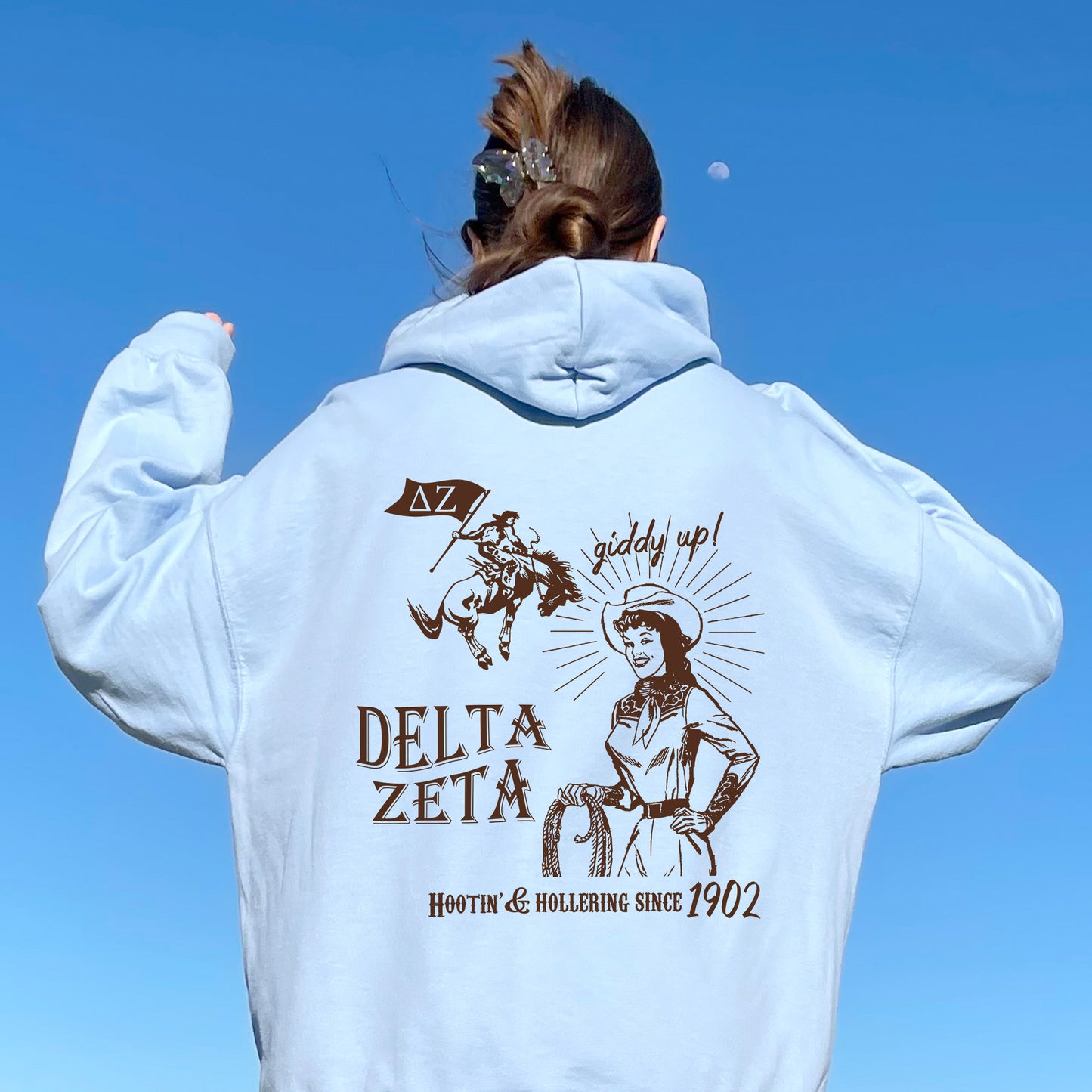 a woman in a white hoodie is flying a kite