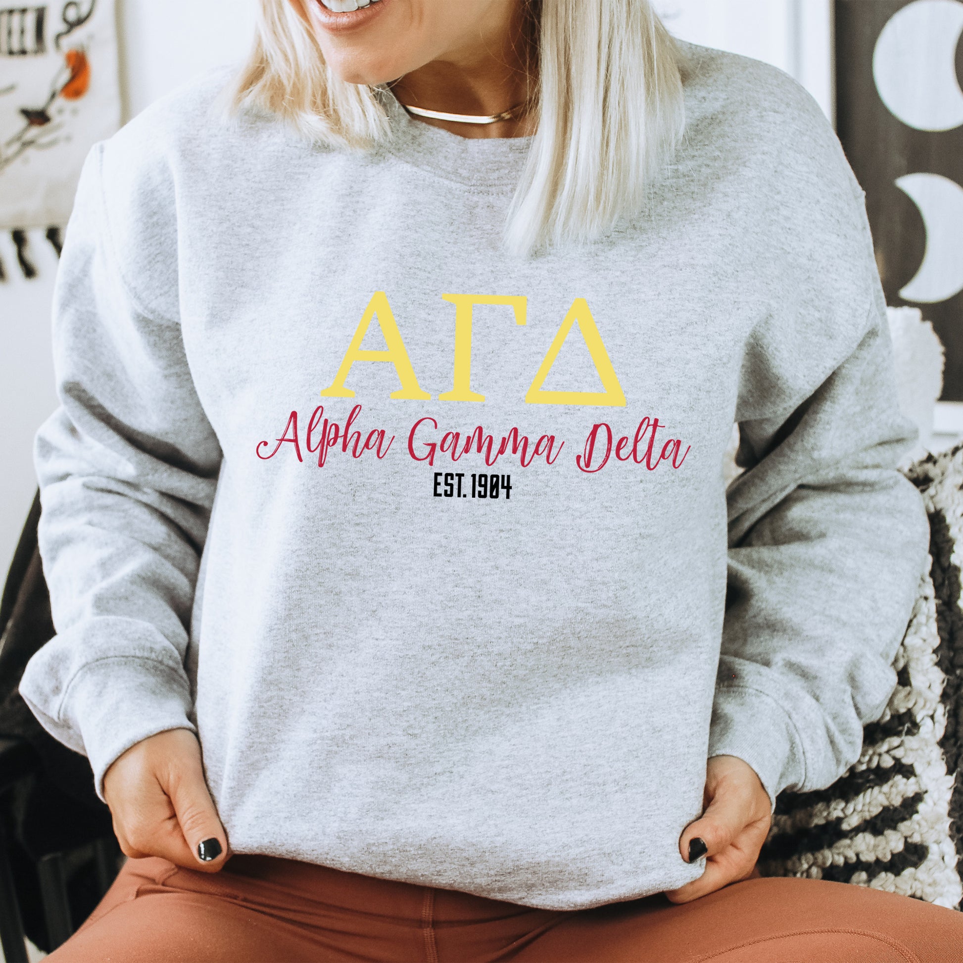 a woman sitting on a chair wearing a sweatshirt