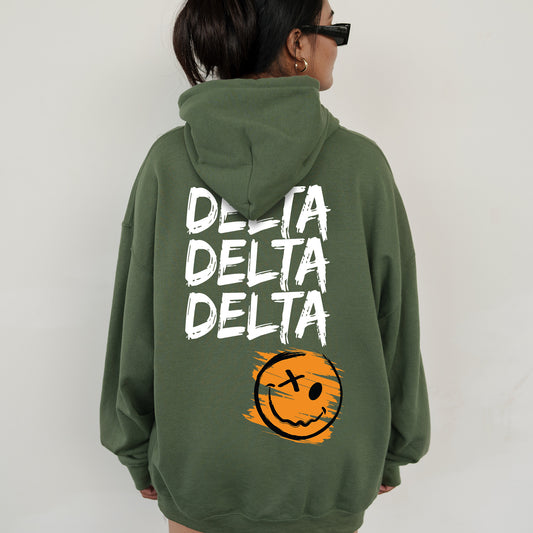 a woman wearing a green sweatshirt with a smiley face on it