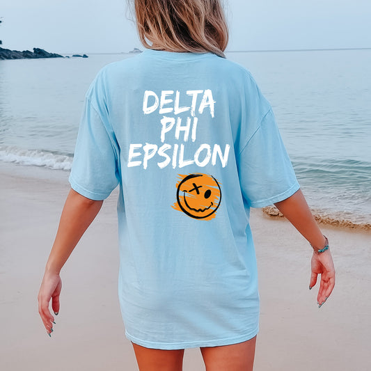 a woman walking on the beach with a smile on her shirt