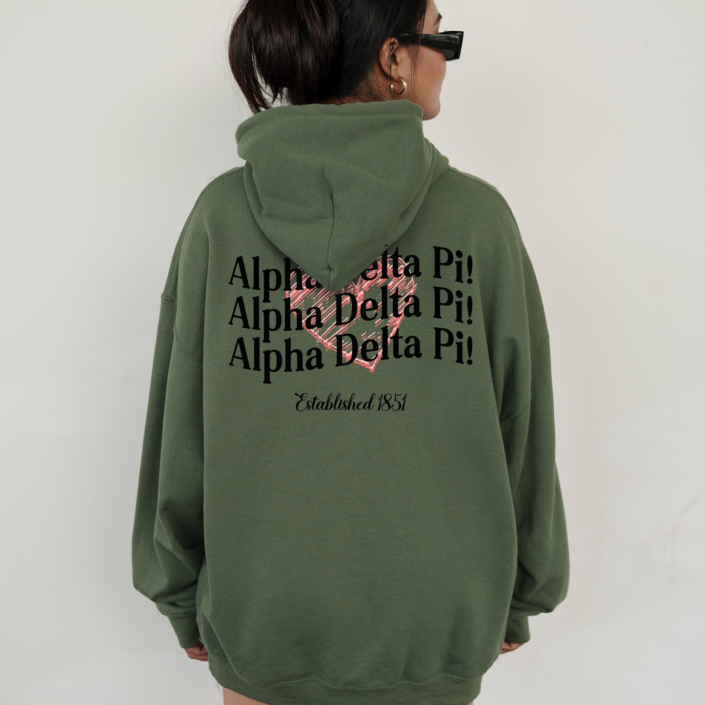 a woman wearing a green hoodie with a pink heart on it
