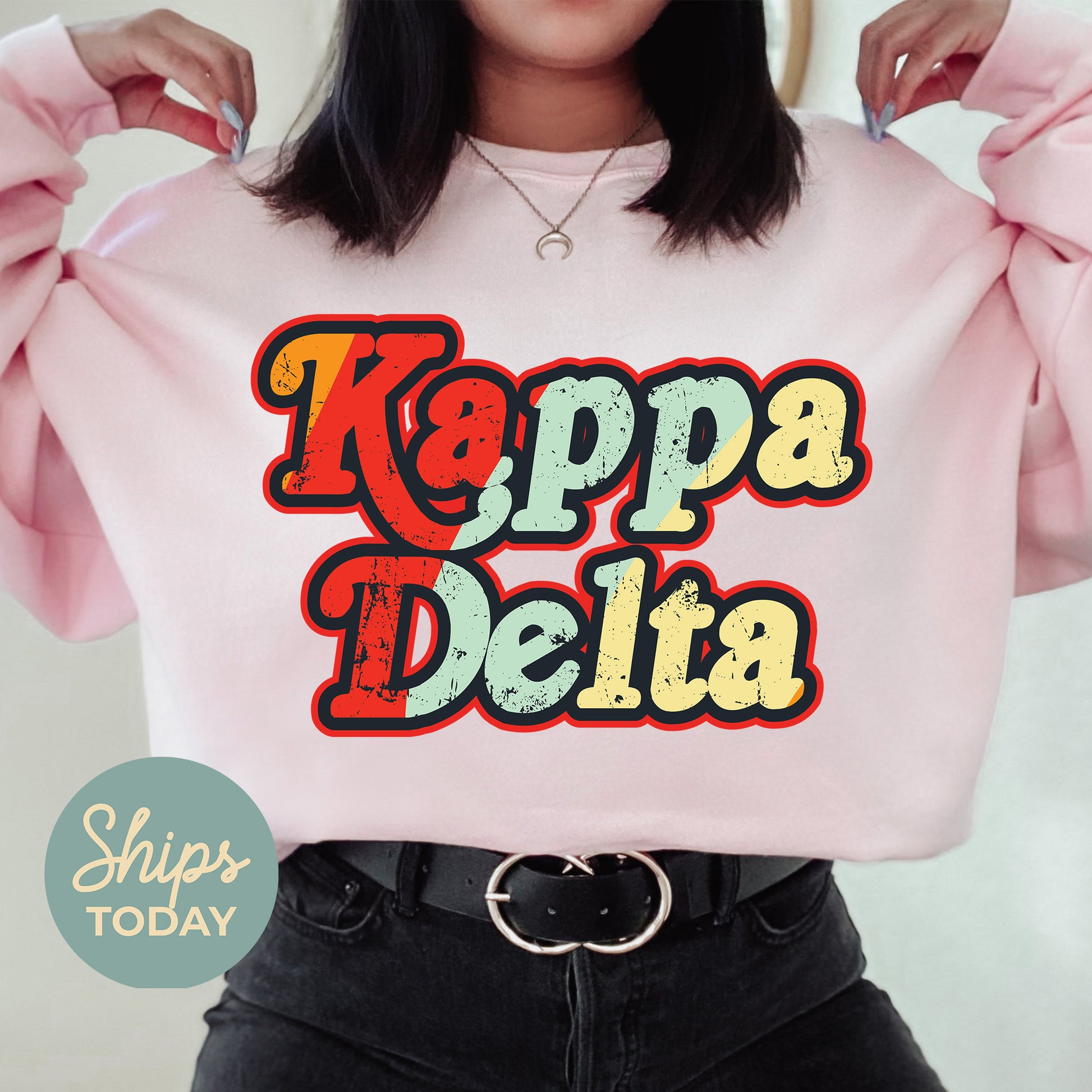 a woman wearing a pink sweatshirt that says kappa delta
