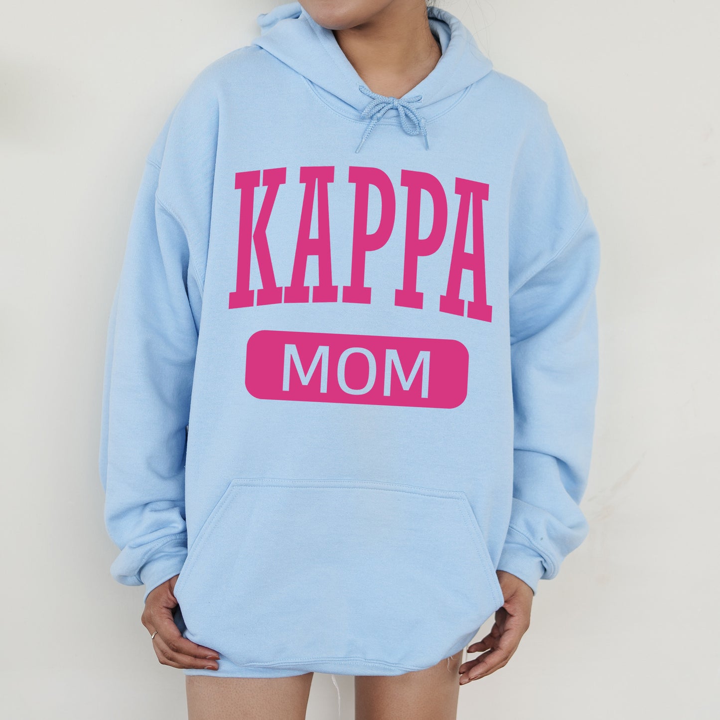 a woman wearing a blue hoodie with the words kappa mom on it