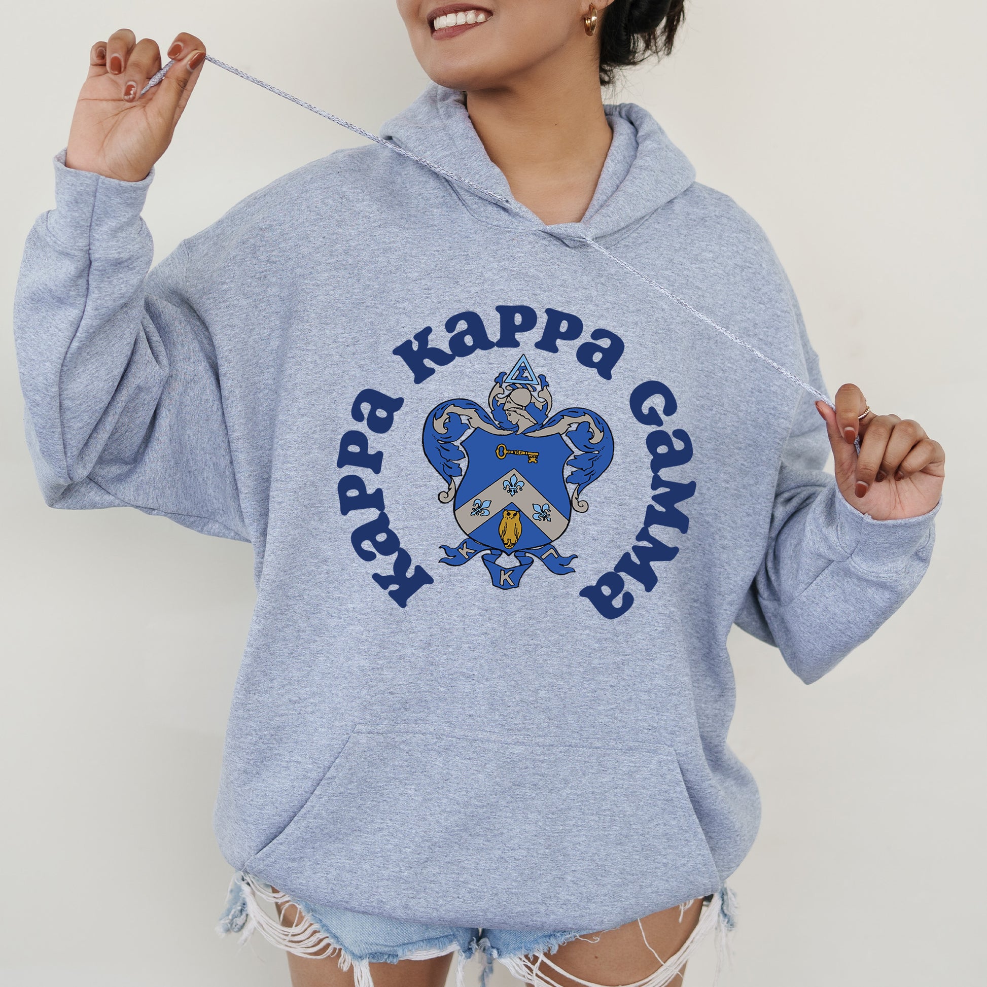 a woman in a blue hoodie holding a toothbrush