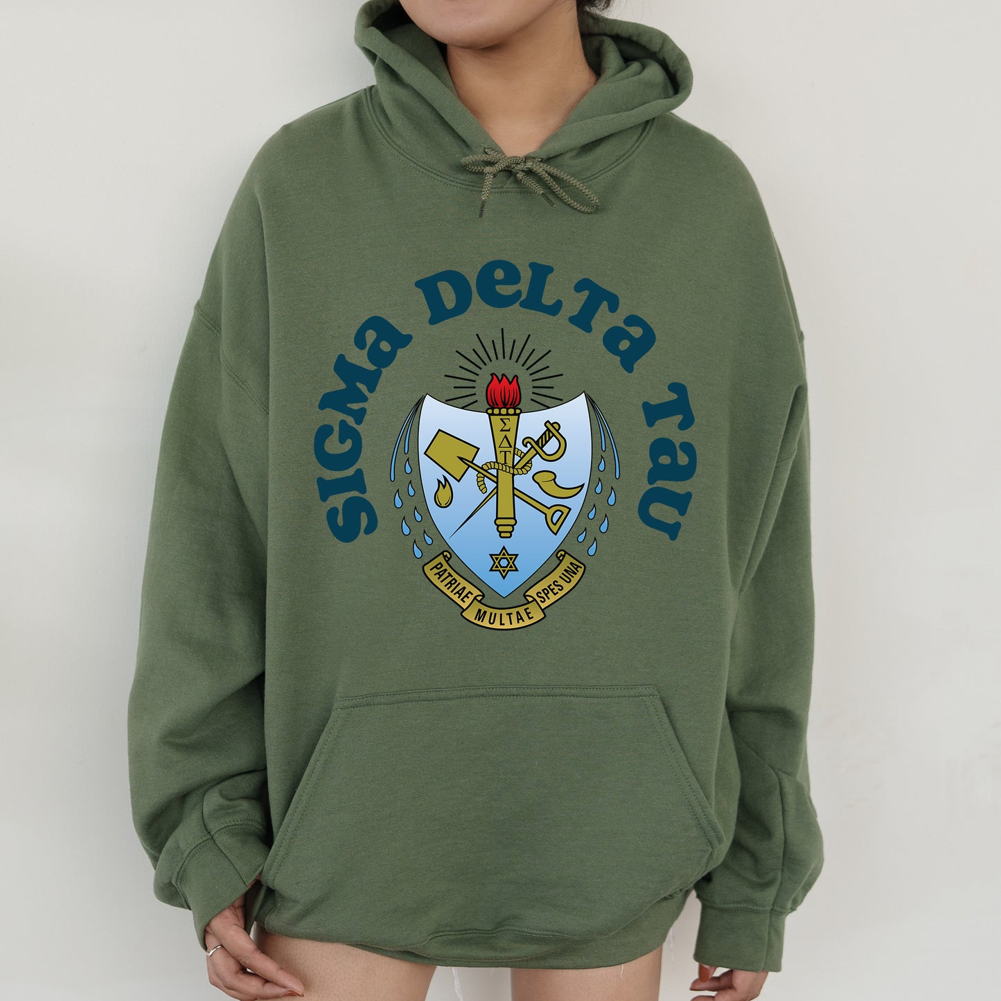 a person wearing a green hoodie with a crest on it