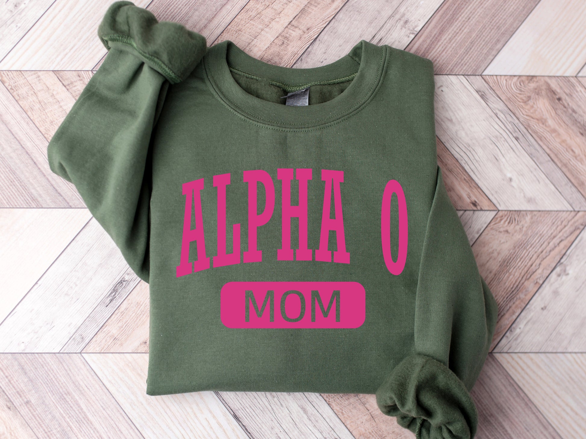 a green sweatshirt with pink letters on it