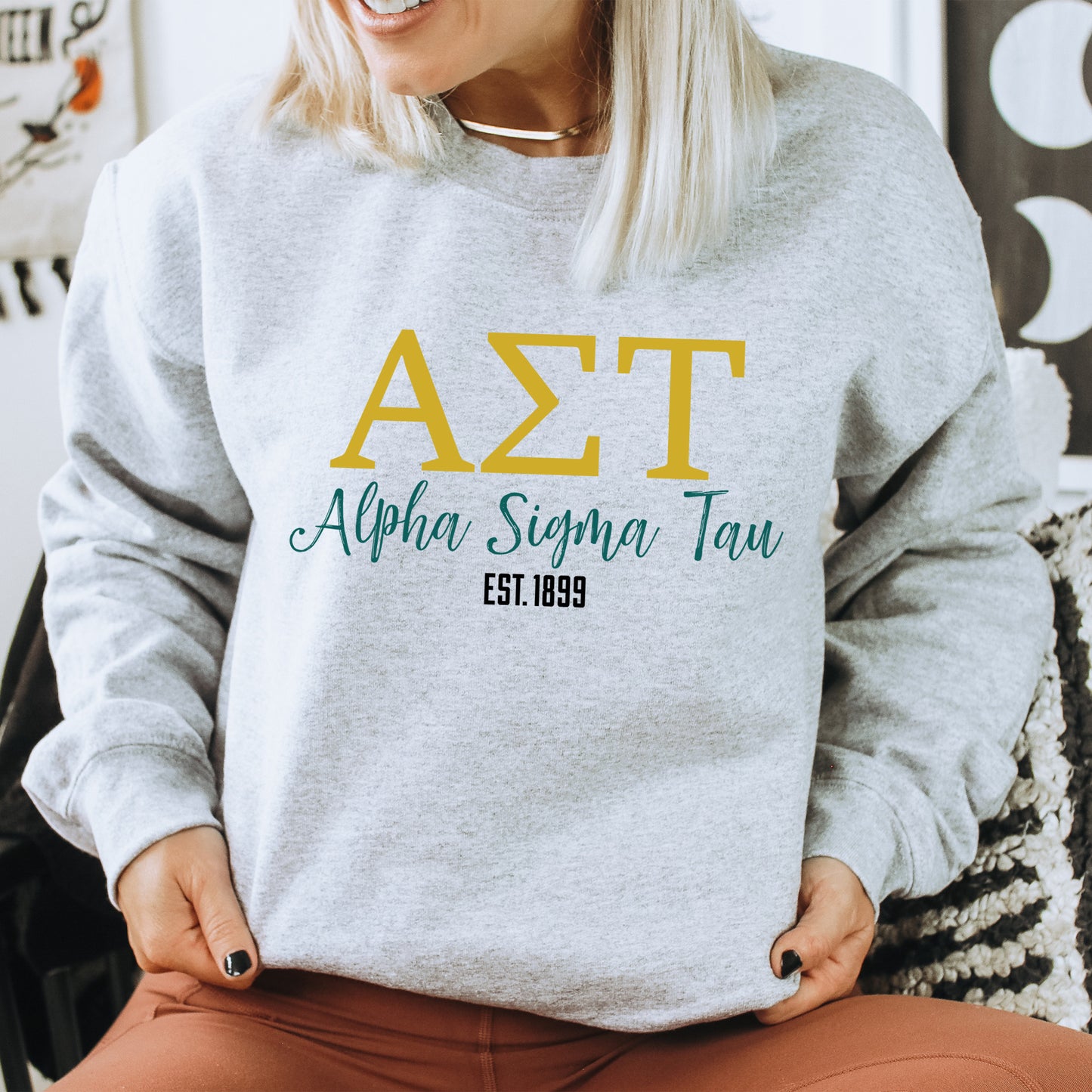 a woman sitting on a chair wearing a grey sweatshirt