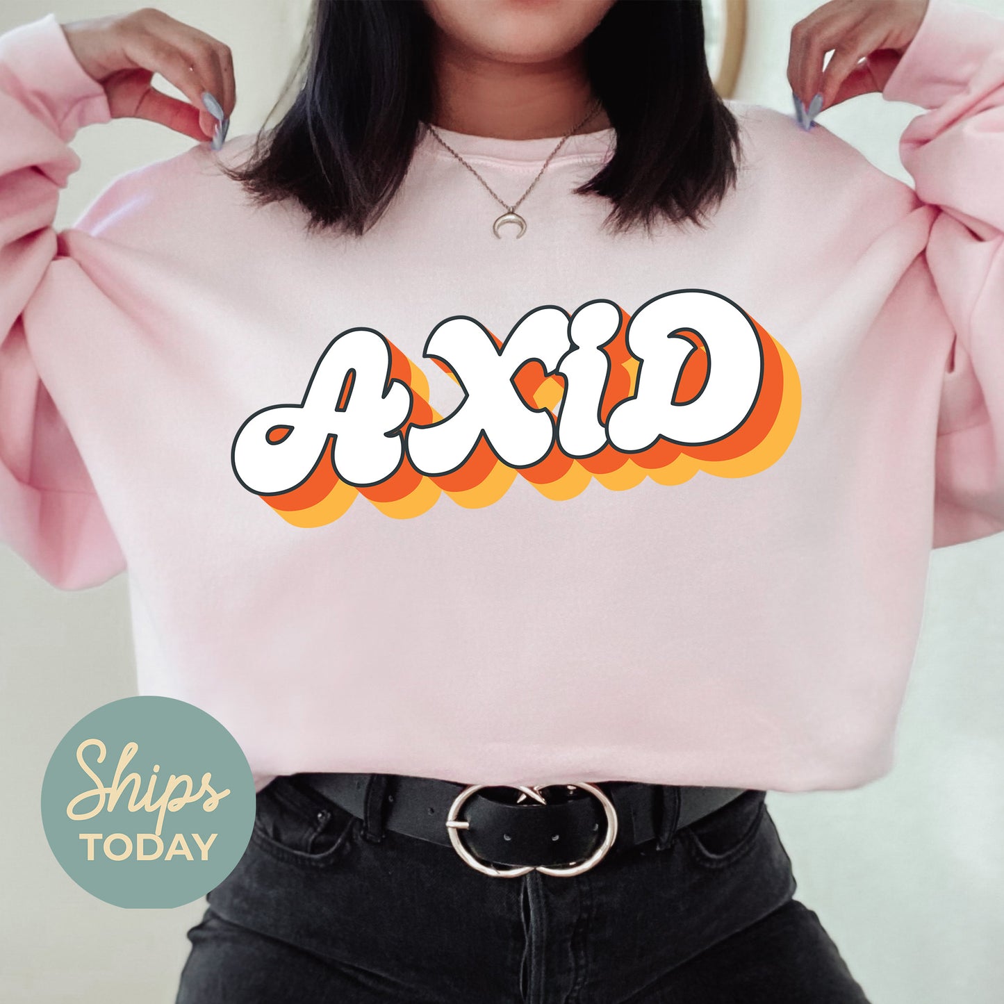 a woman wearing a pink sweatshirt with the word axd printed on it