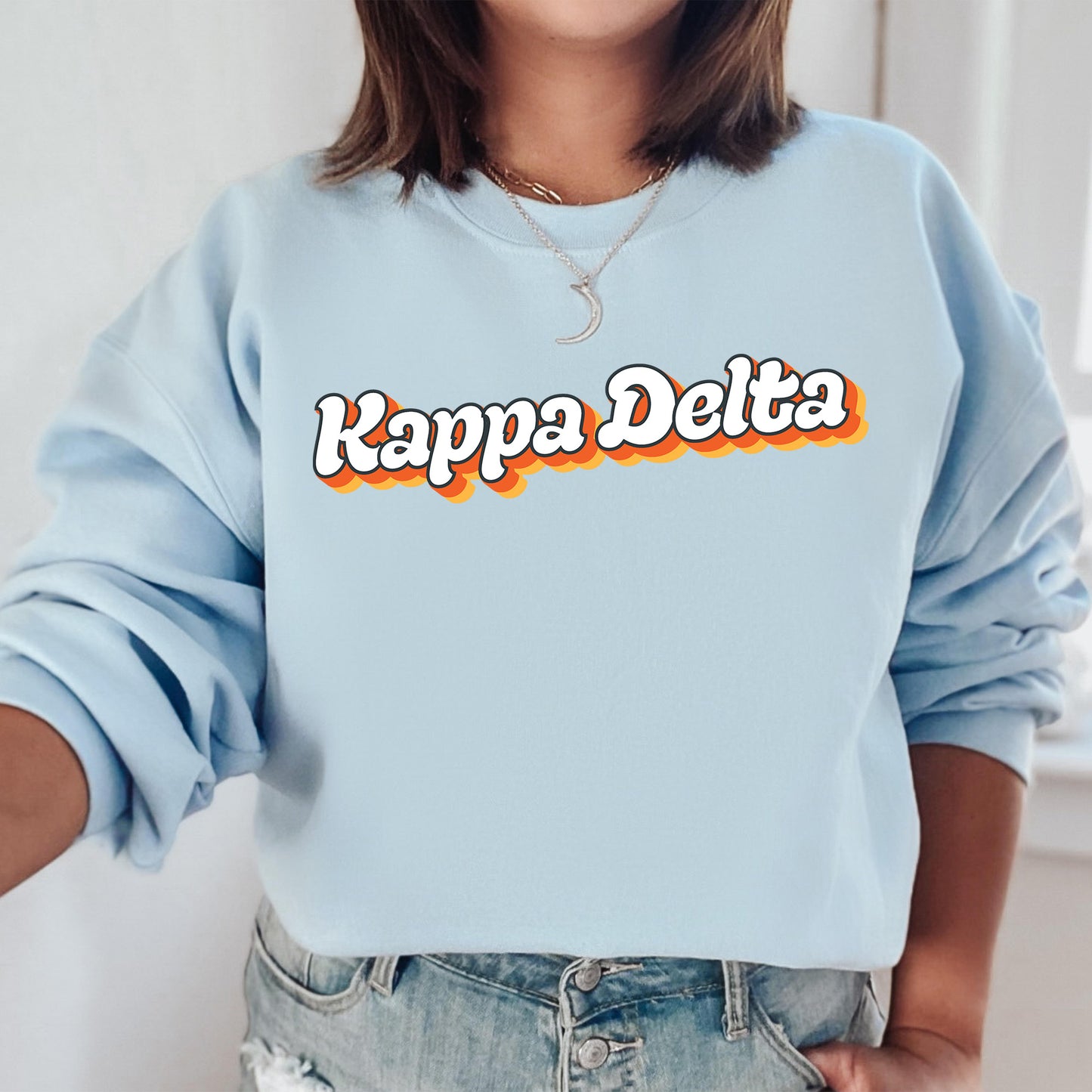 a woman wearing a blue sweatshirt that says kappa delta
