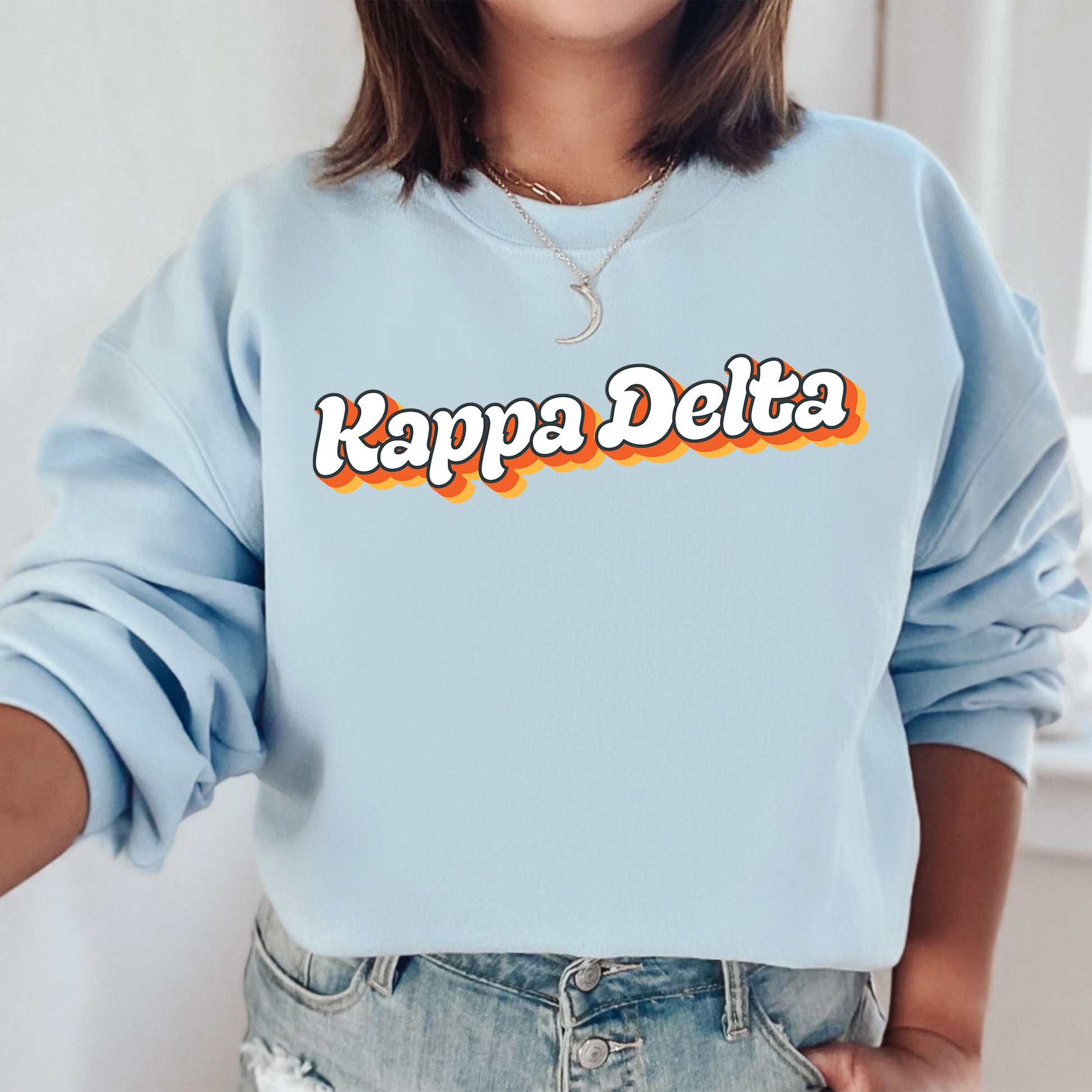a woman wearing a blue sweatshirt that says kappa delta