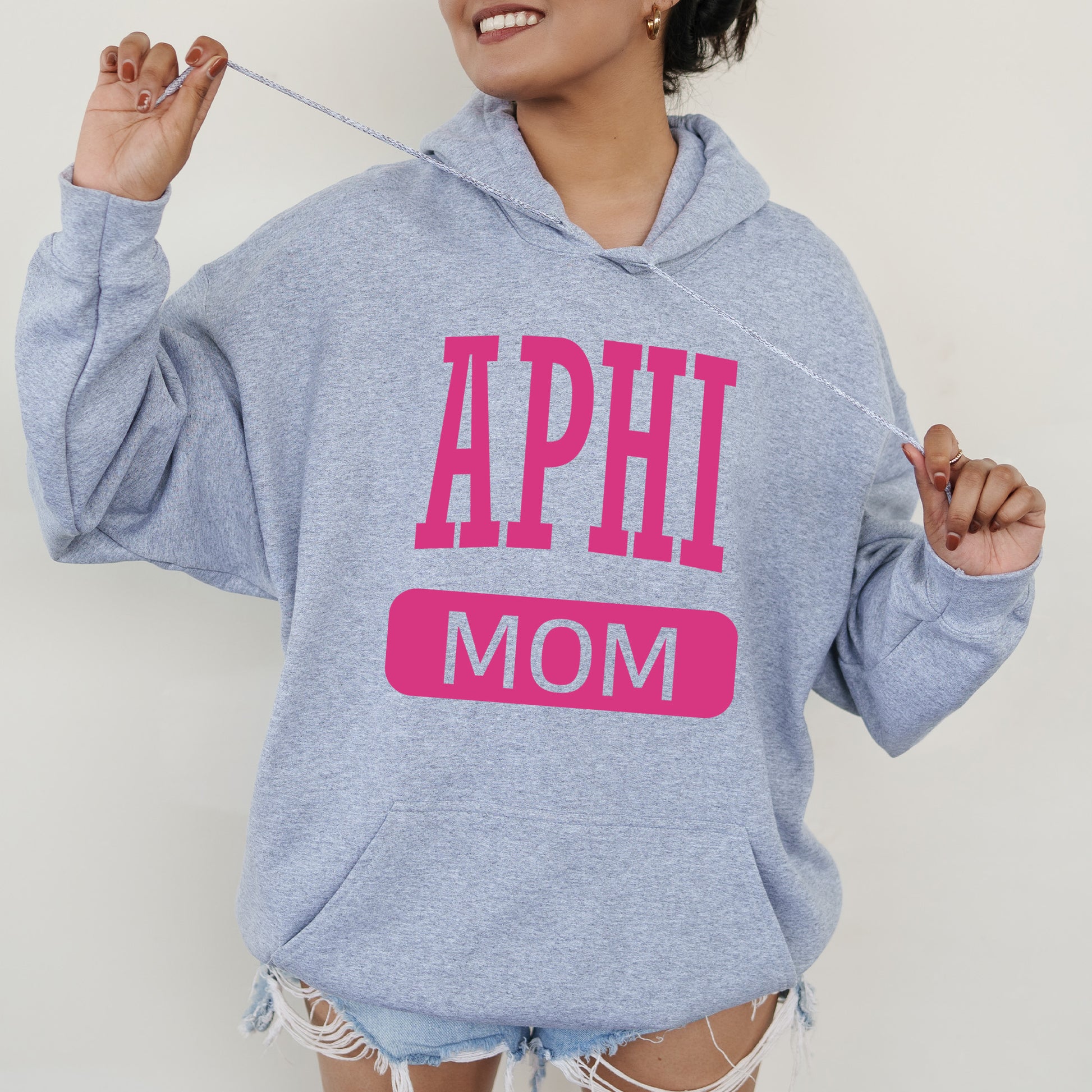 a woman wearing a sweatshirt that says aphi mom