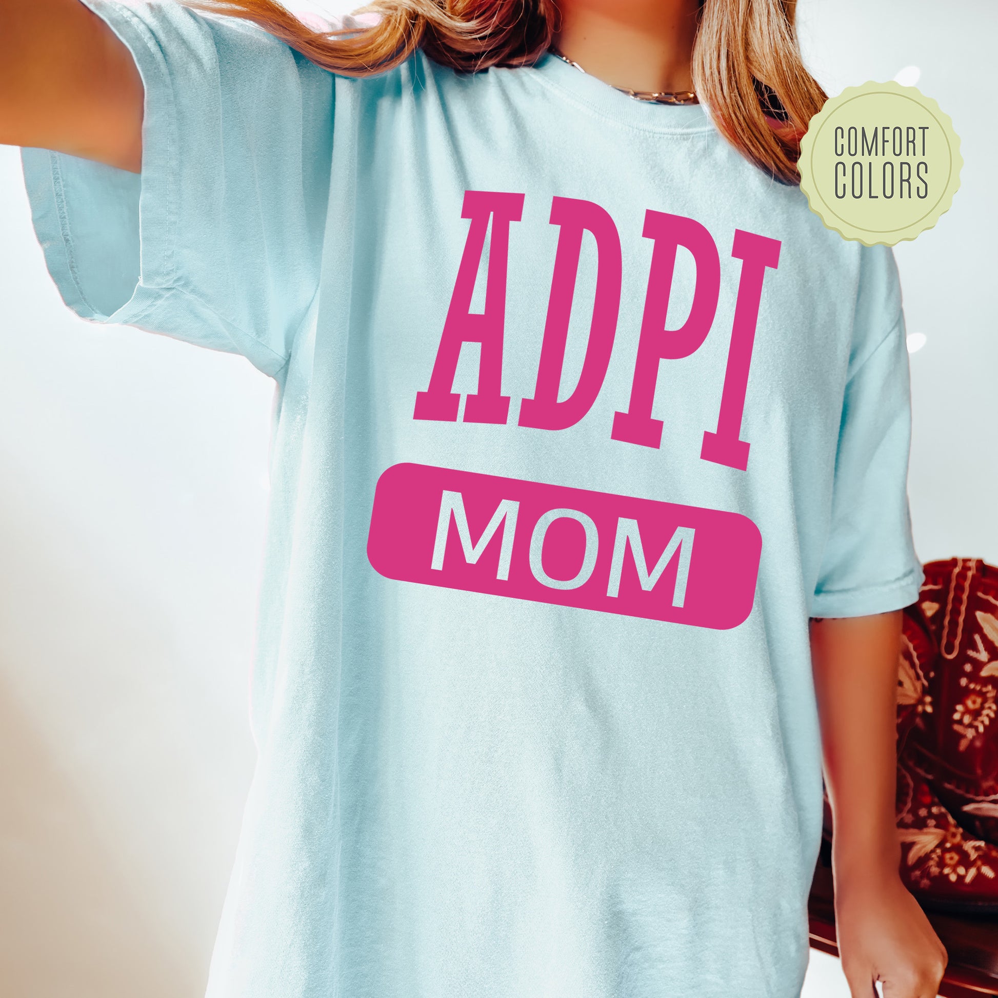 a woman wearing a t - shirt that says adpi mom