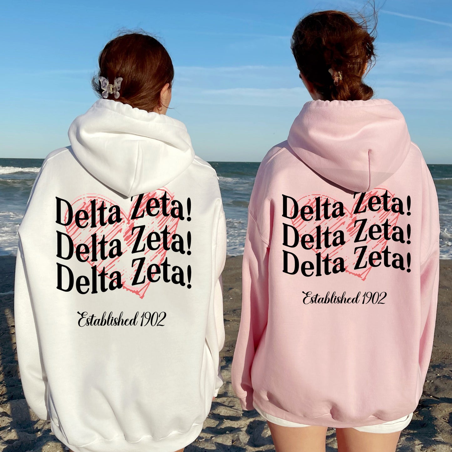 two women in matching sweatshirts on the beach