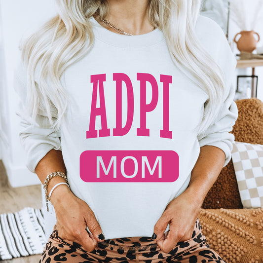 a woman wearing a sweatshirt with the words adpi mom printed on it
