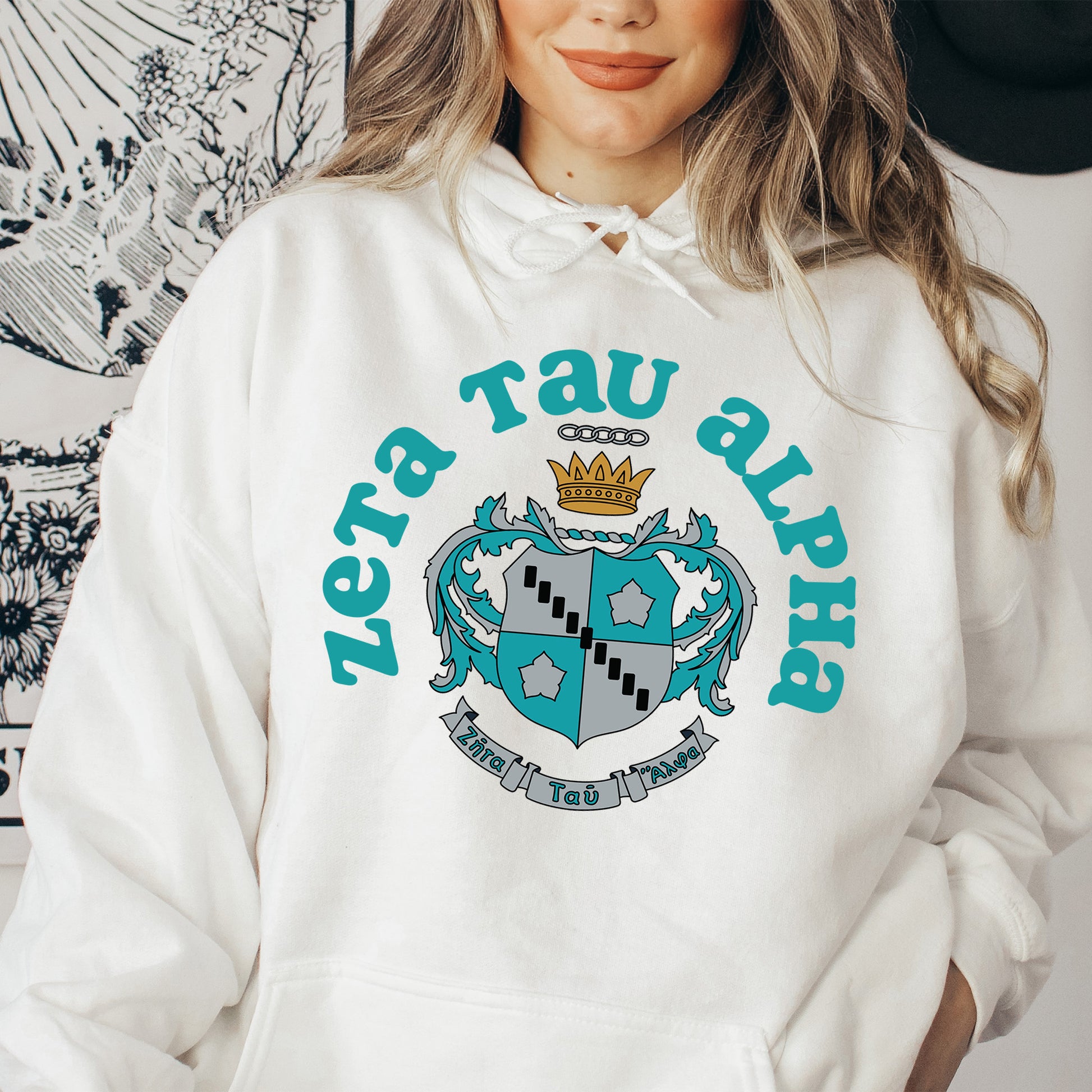 a woman wearing a white hoodie with a crown on it