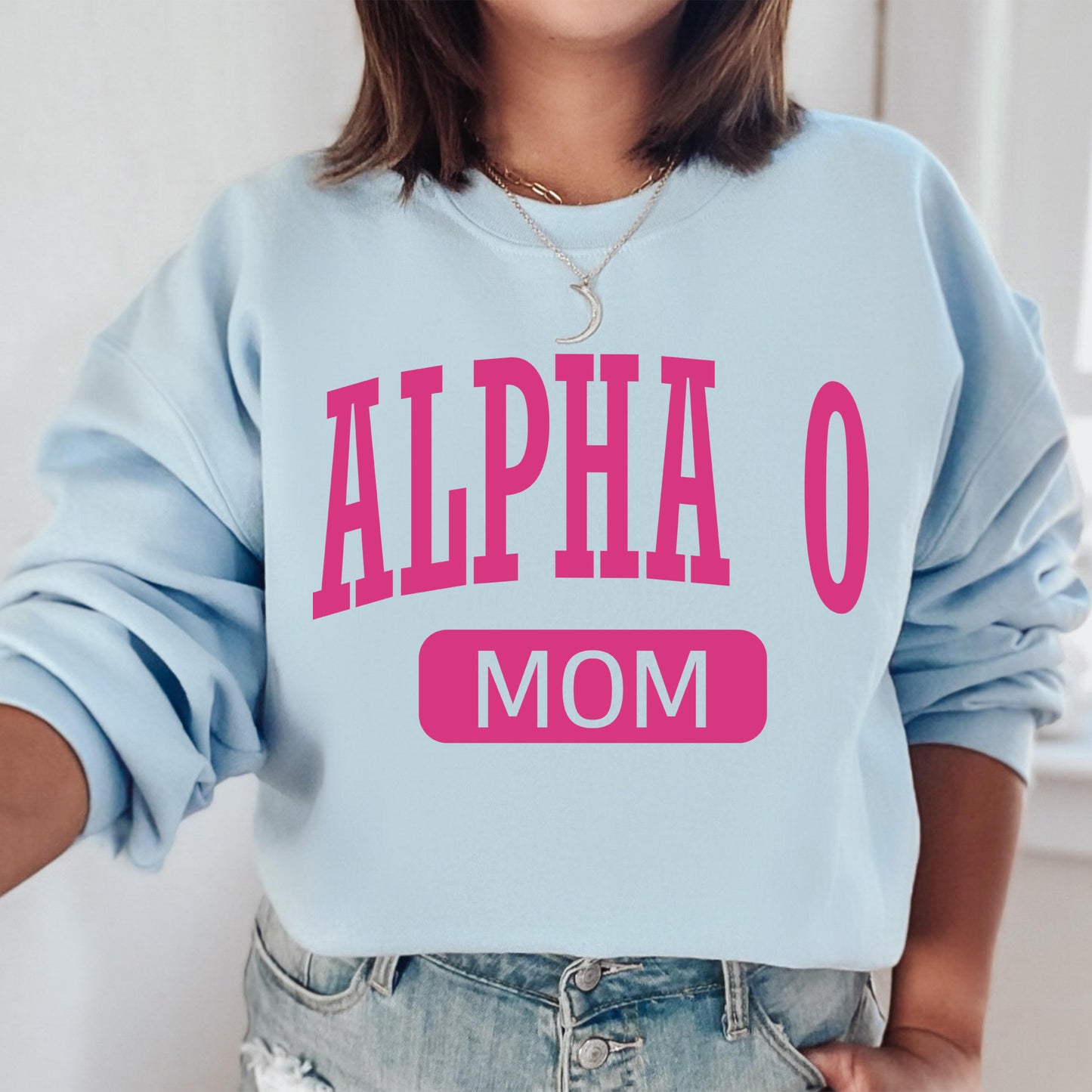 a woman wearing a blue sweatshirt with pink letters on it