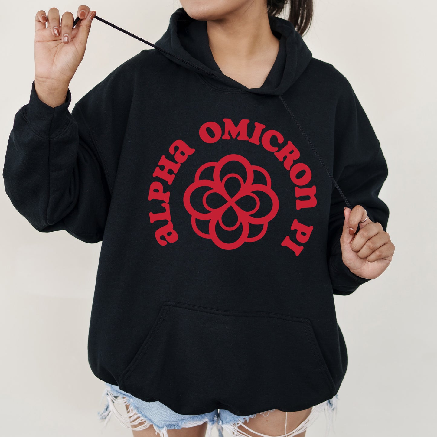 a woman in a black hoodie holding a stick