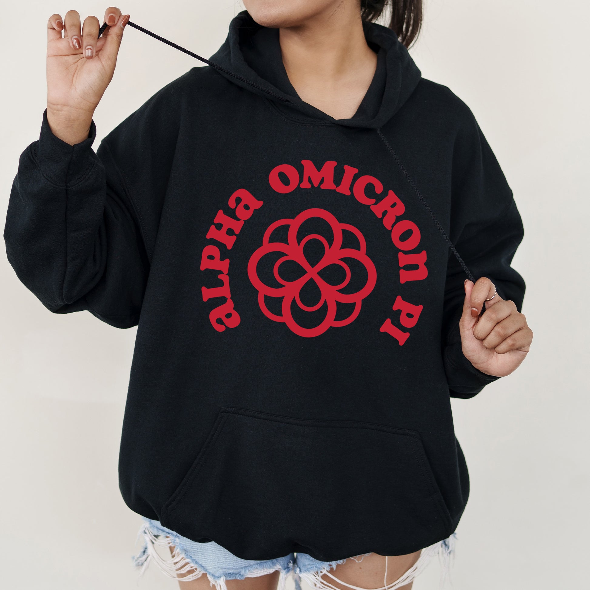 a woman in a black hoodie holding a stick