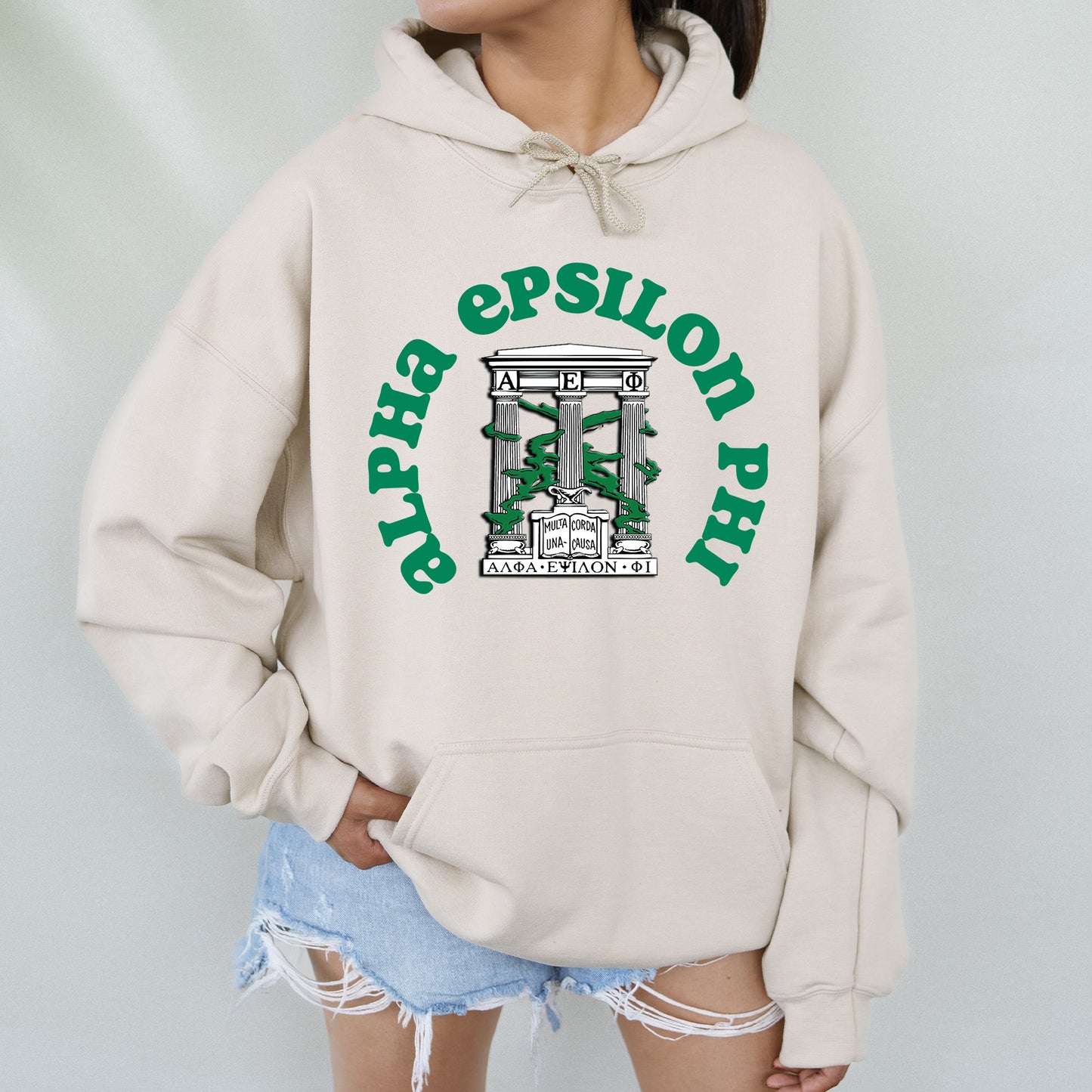 a woman wearing a white sweatshirt with a green logo on it