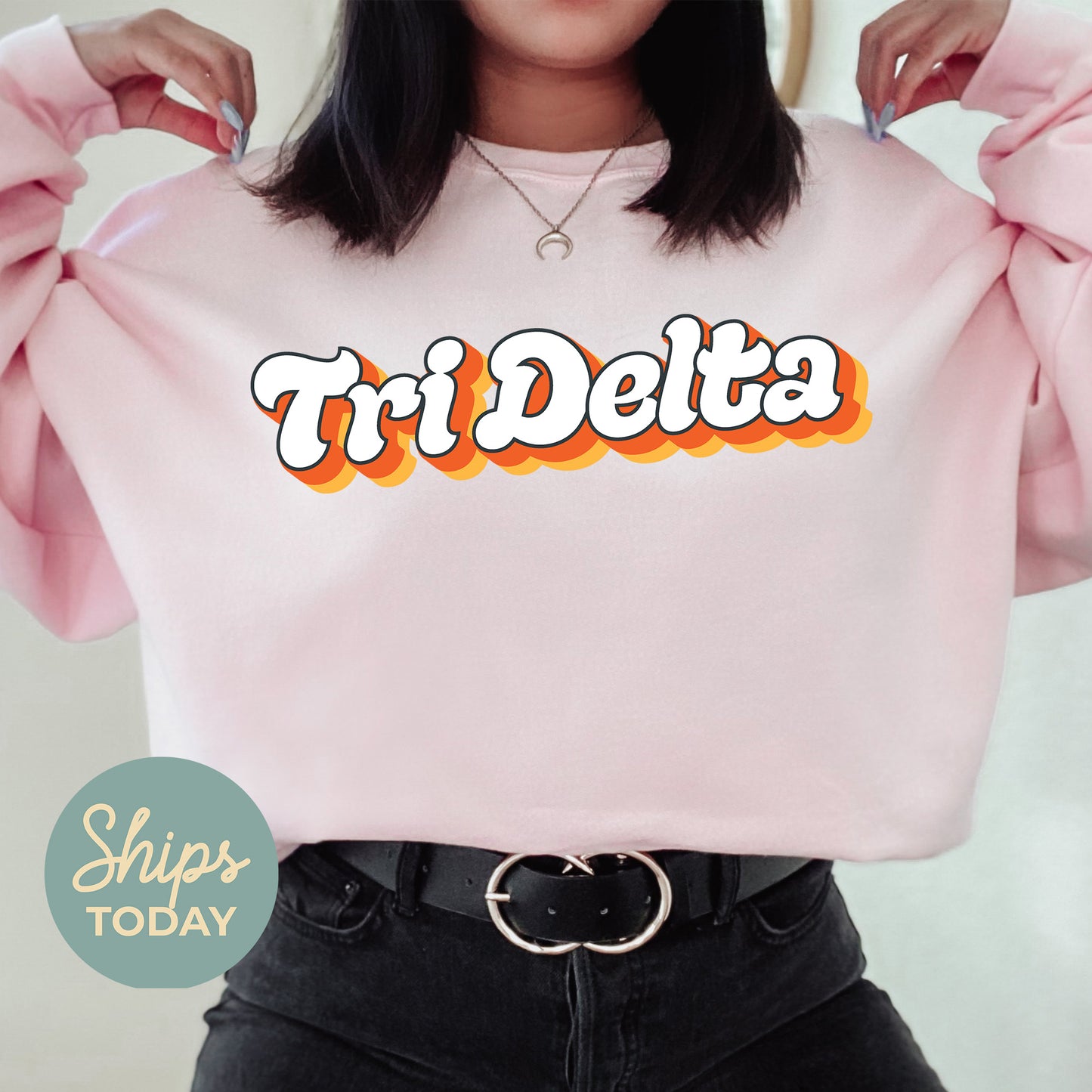 a woman wearing a pink shirt with the word tri delta on it