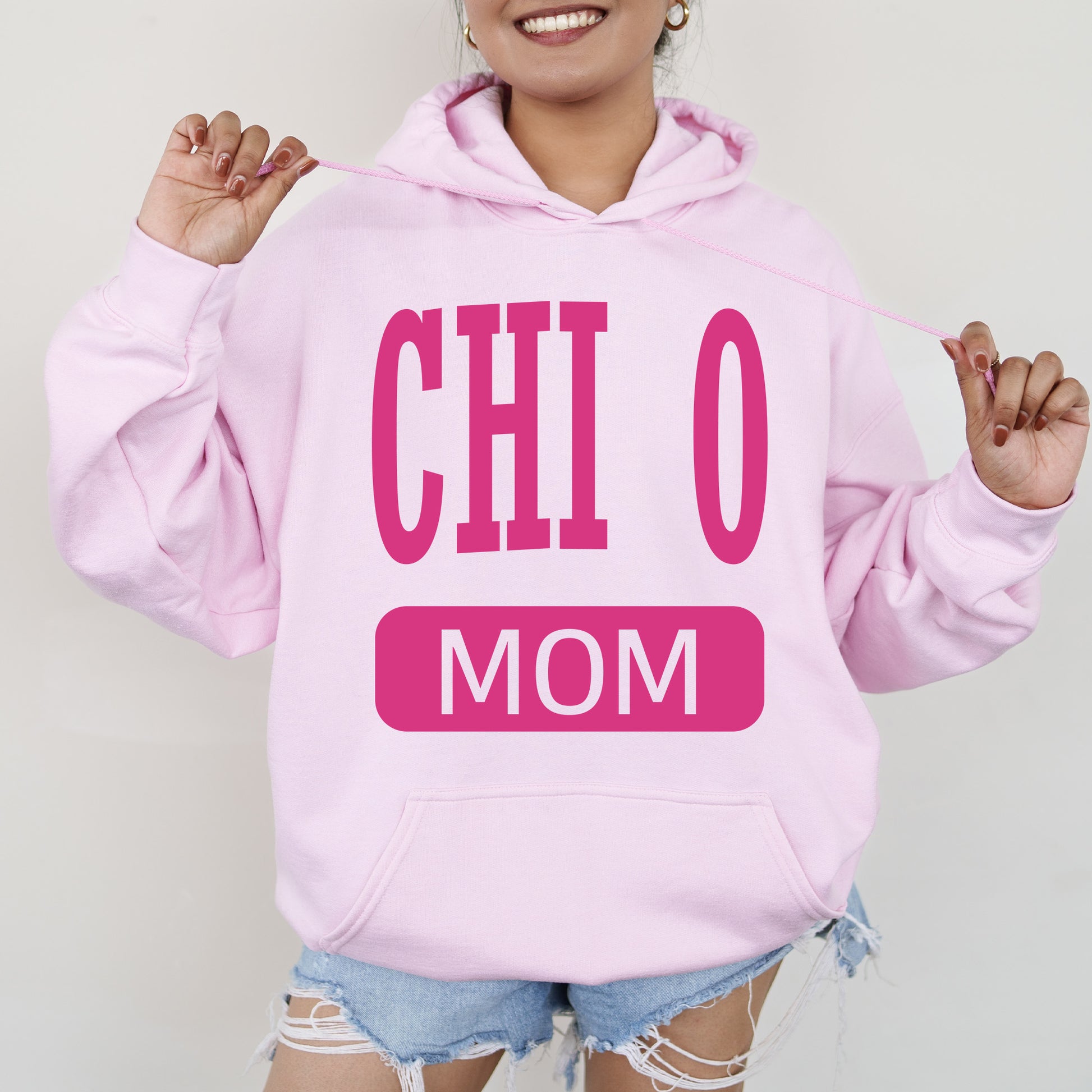 a woman wearing a pink hoodie that says,'oh mom '